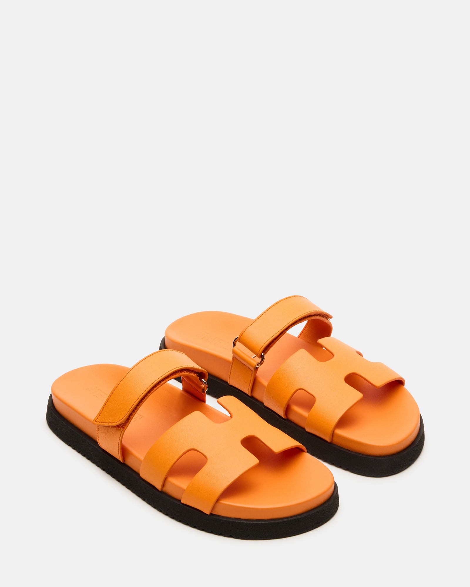 Styled image of women wearing leather slides with casual outfit outdoors