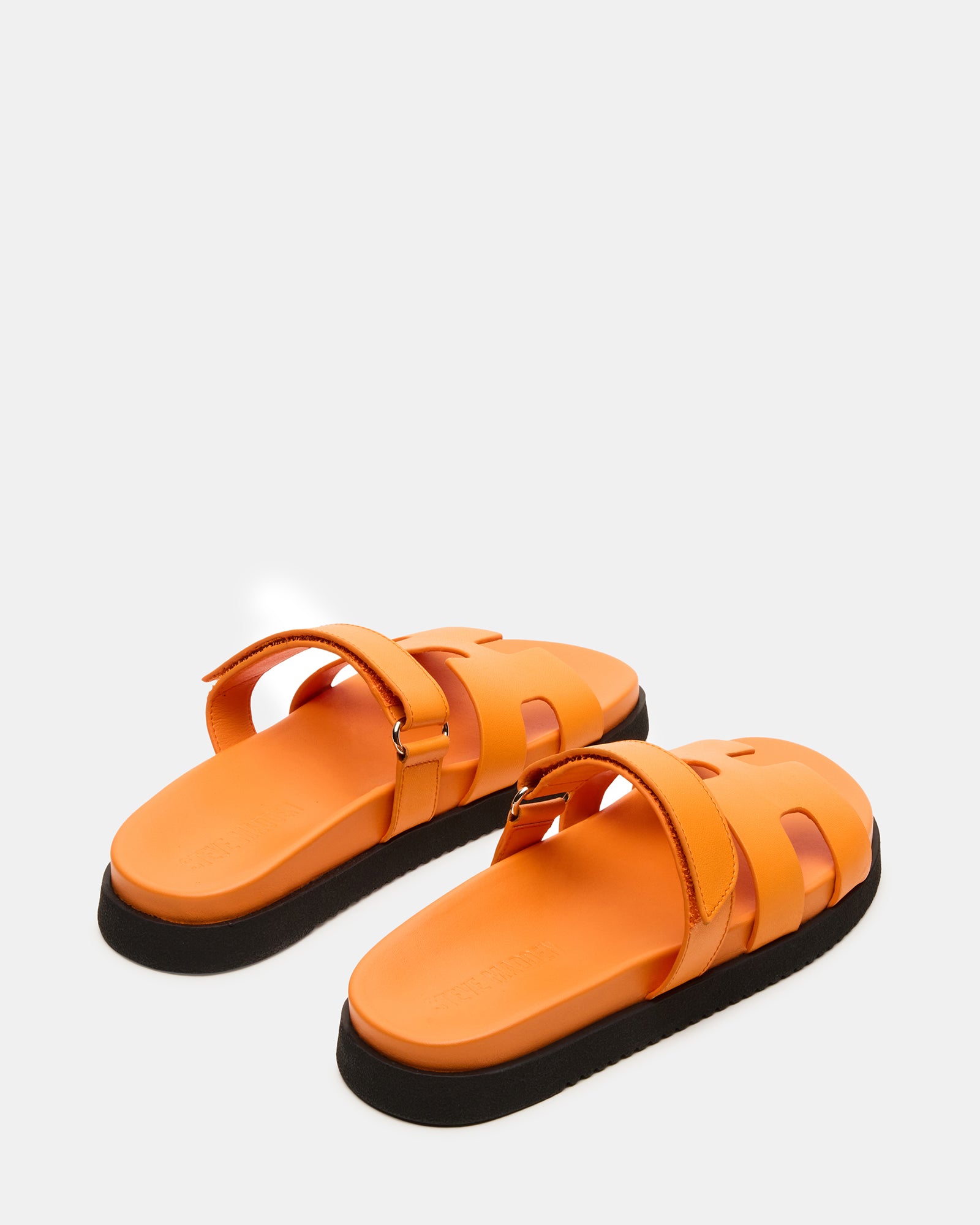 Styled image of women wearing leather slides with casual outfit outdoors