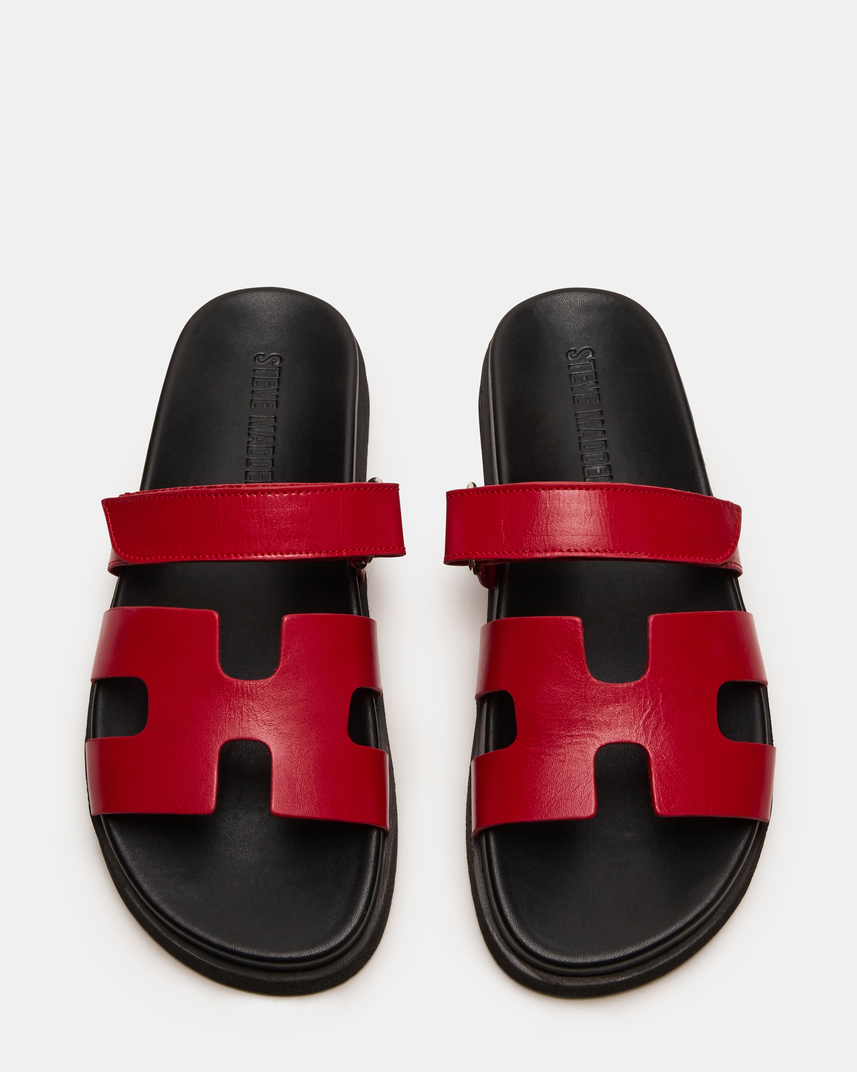 Top view of MAYVEN red leather slides emphasizing the adjustable strap and molded footbed.