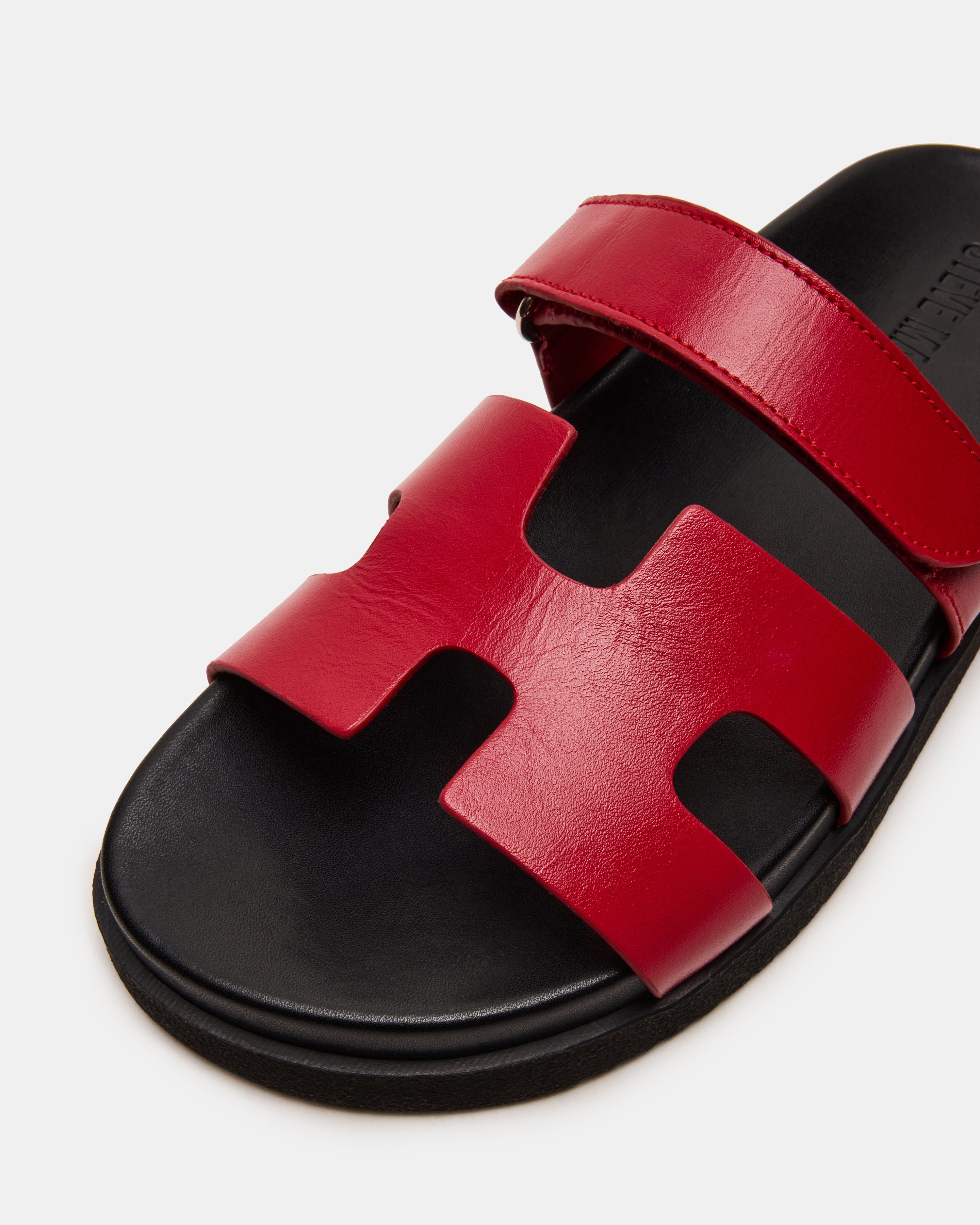 Side view of MAYVEN red leather flatform slides highlighting the geometric cutout design.