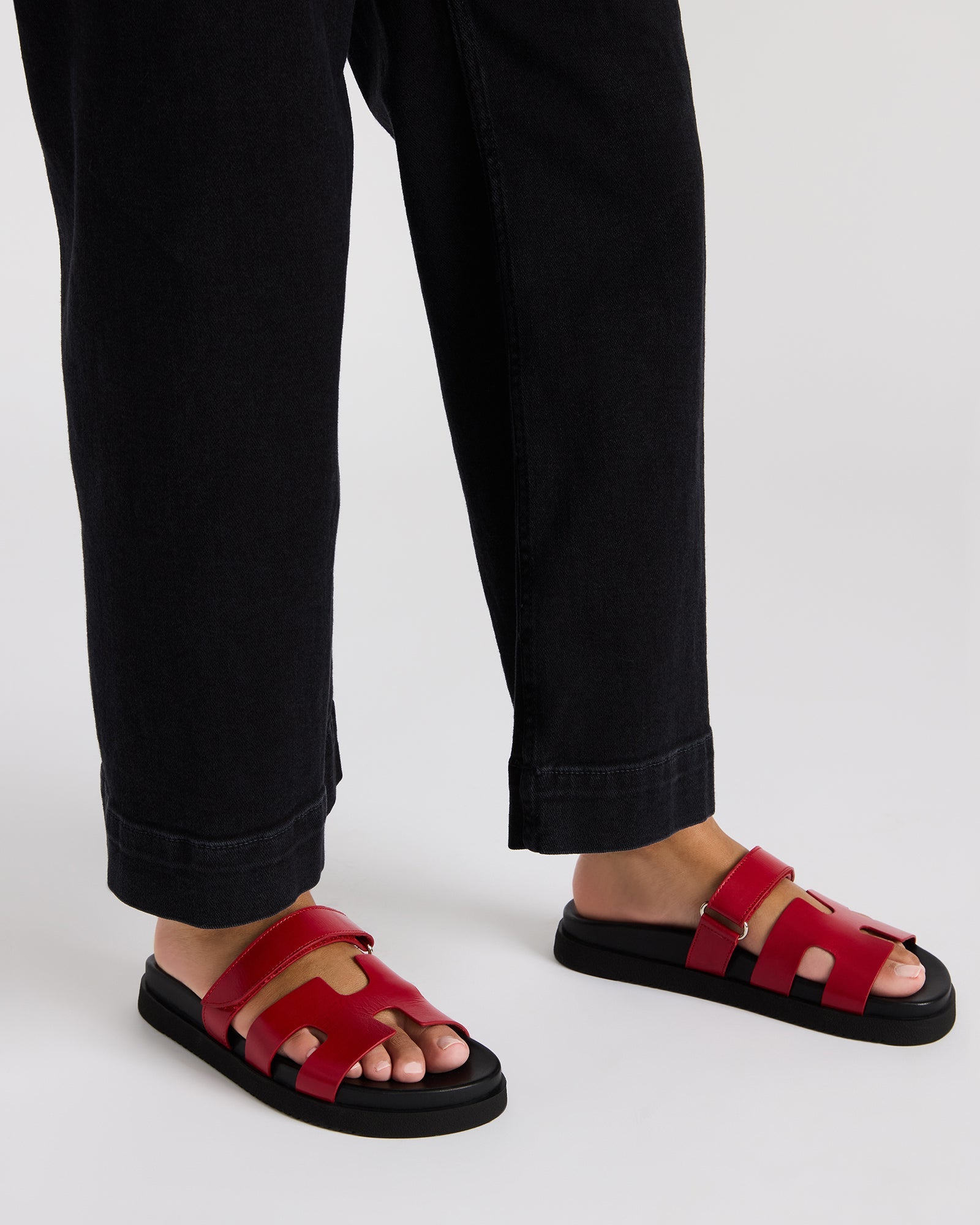 Top view of MAYVEN red leather slides emphasizing the adjustable strap and molded footbed.