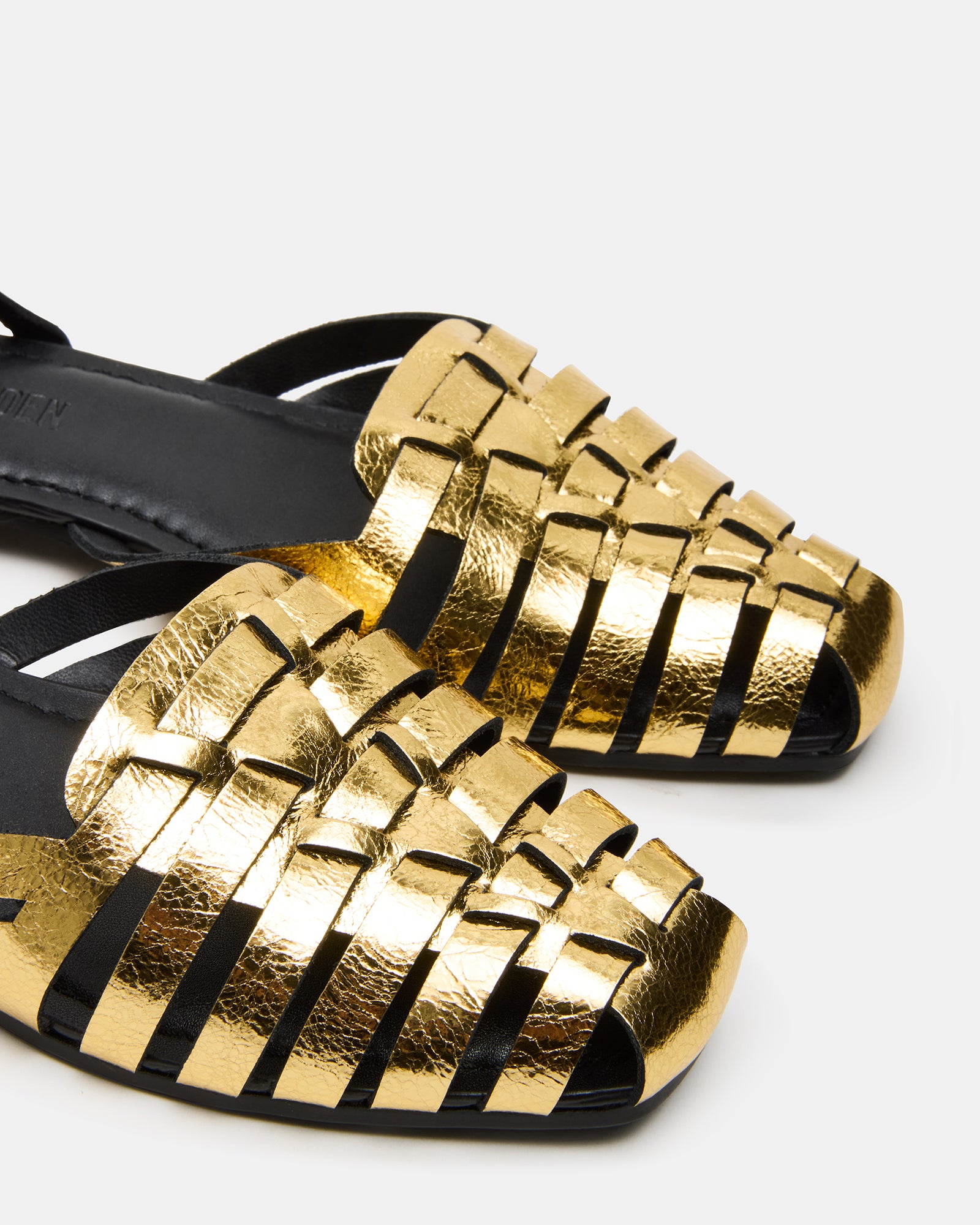 Close-up of fisherman flats in gold leather, showing heel and stitching