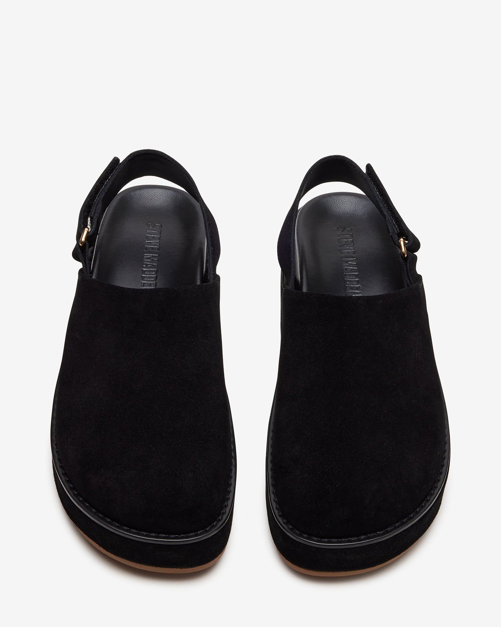 Side view of black suede slingback clogs styled with cropped jeans