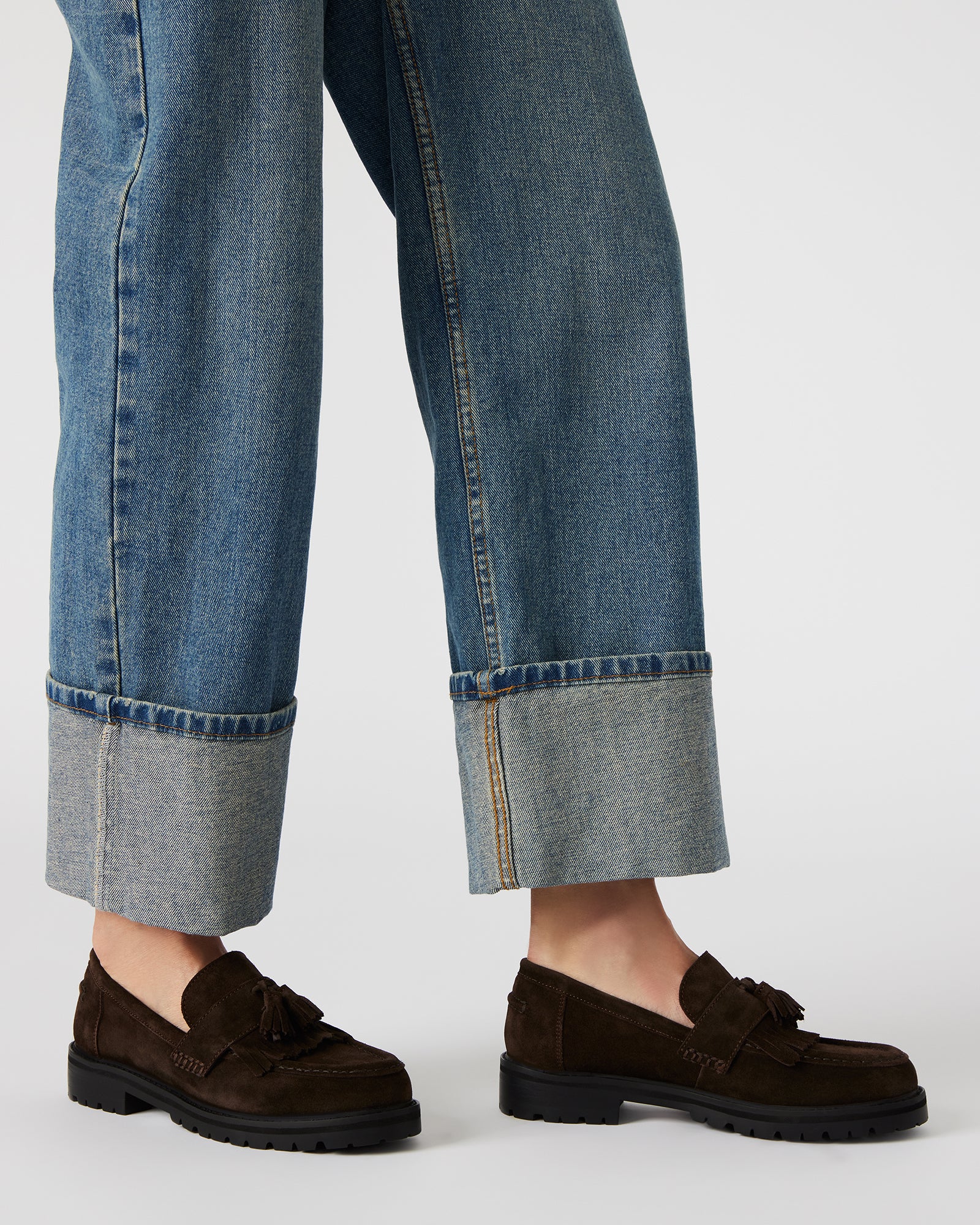 Mens black leather loafers paired with dark denim