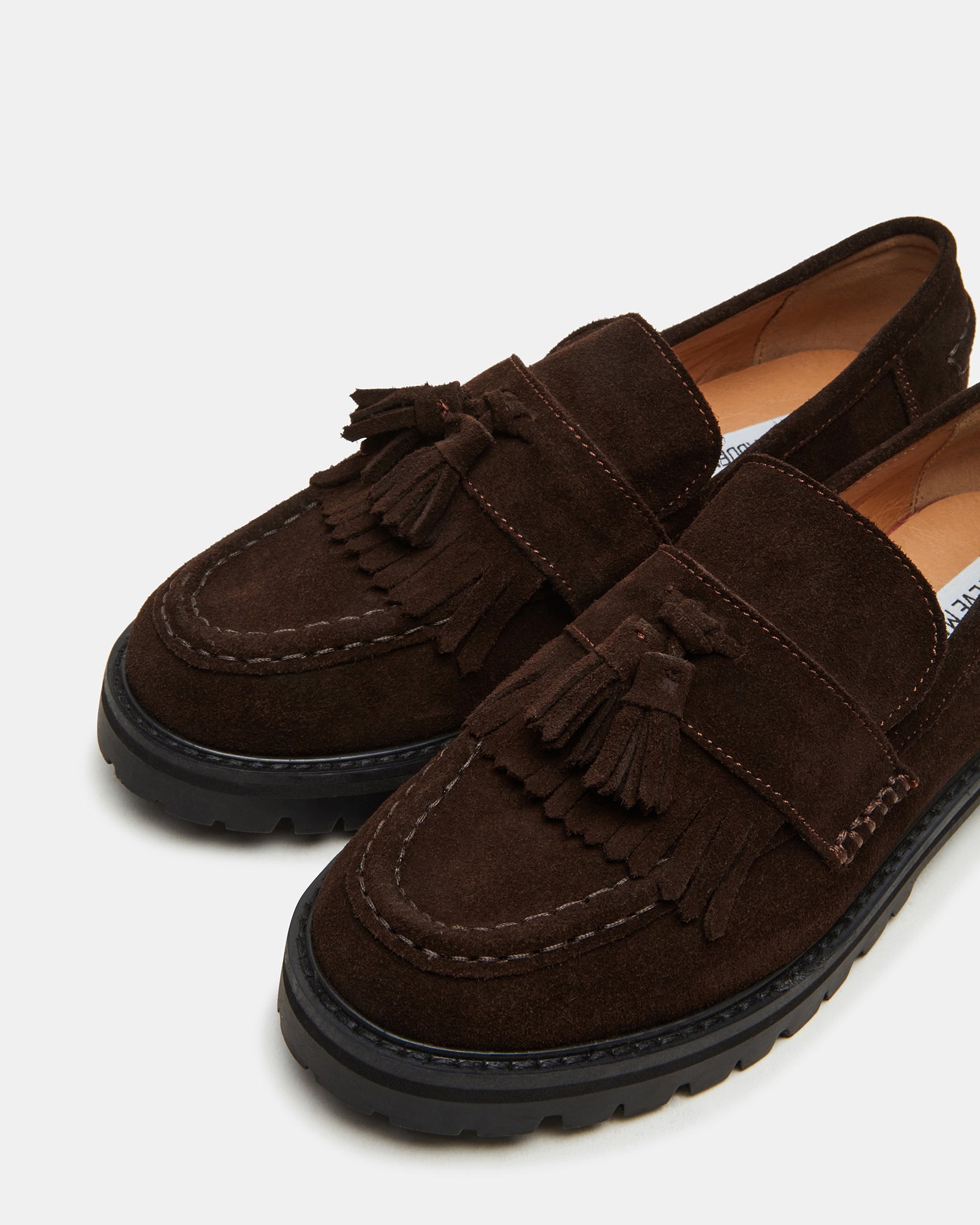 Minka penny loafers in chocolate suede, displayed on a rustic wooden surface.