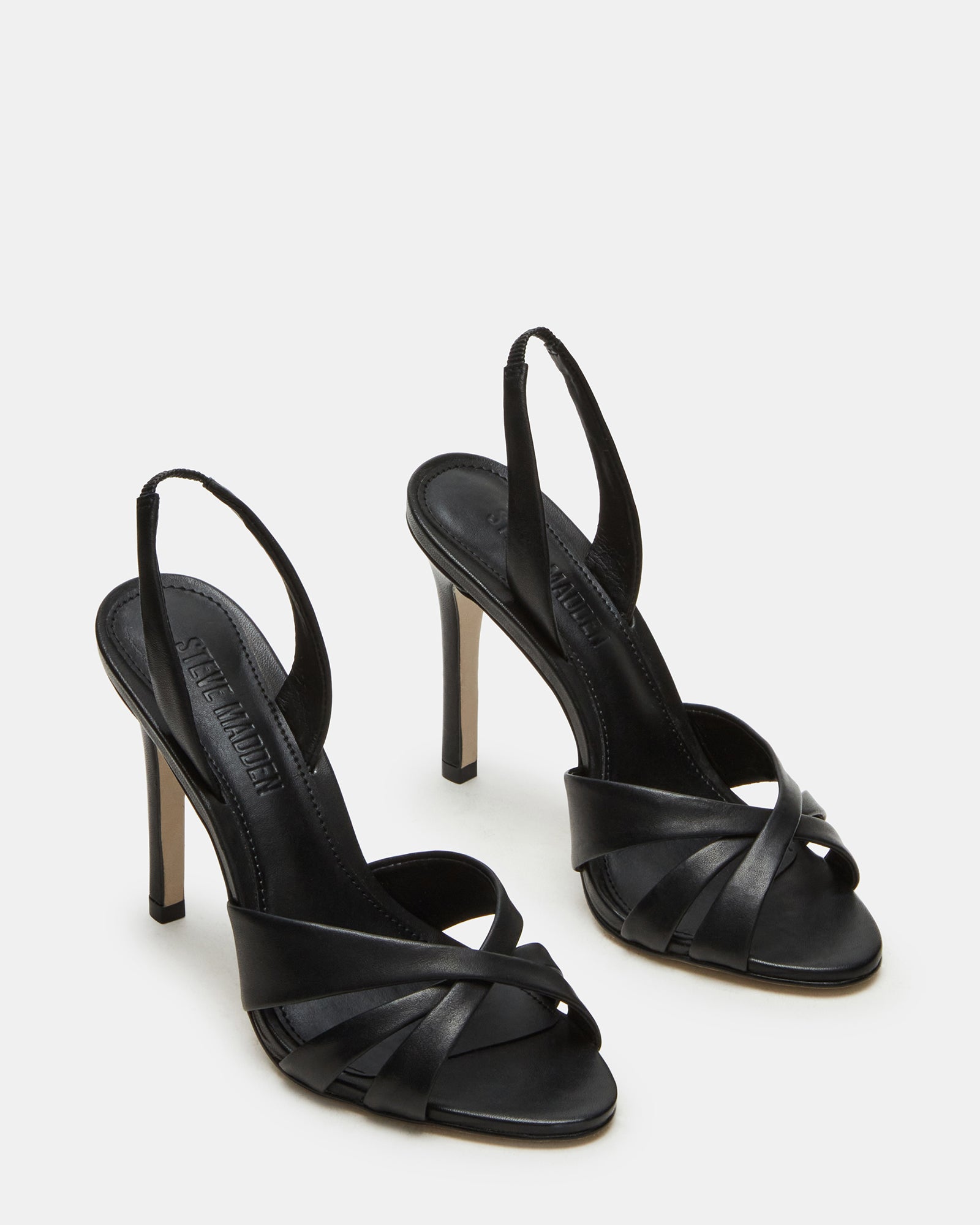 Side profile of black stiletto heels showcasing the 4.25-inch heel on a wooden surface