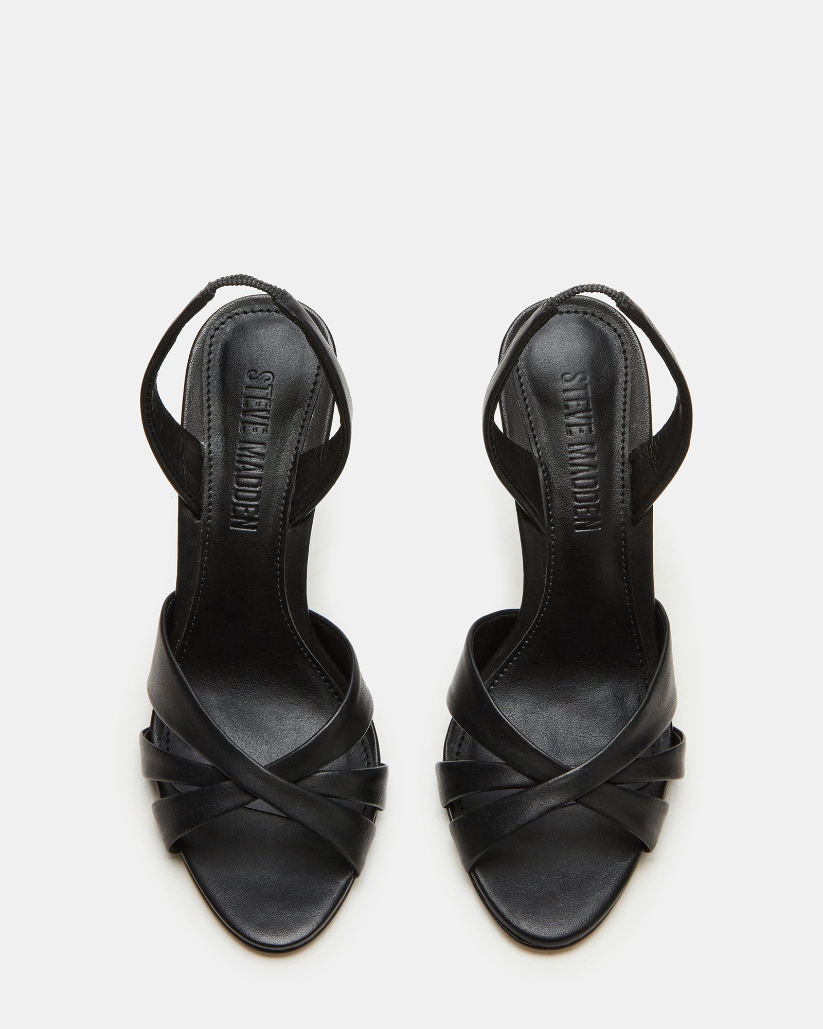 Close-up of MINX black patent leather stiletto heels highlighting the slingback strap detail