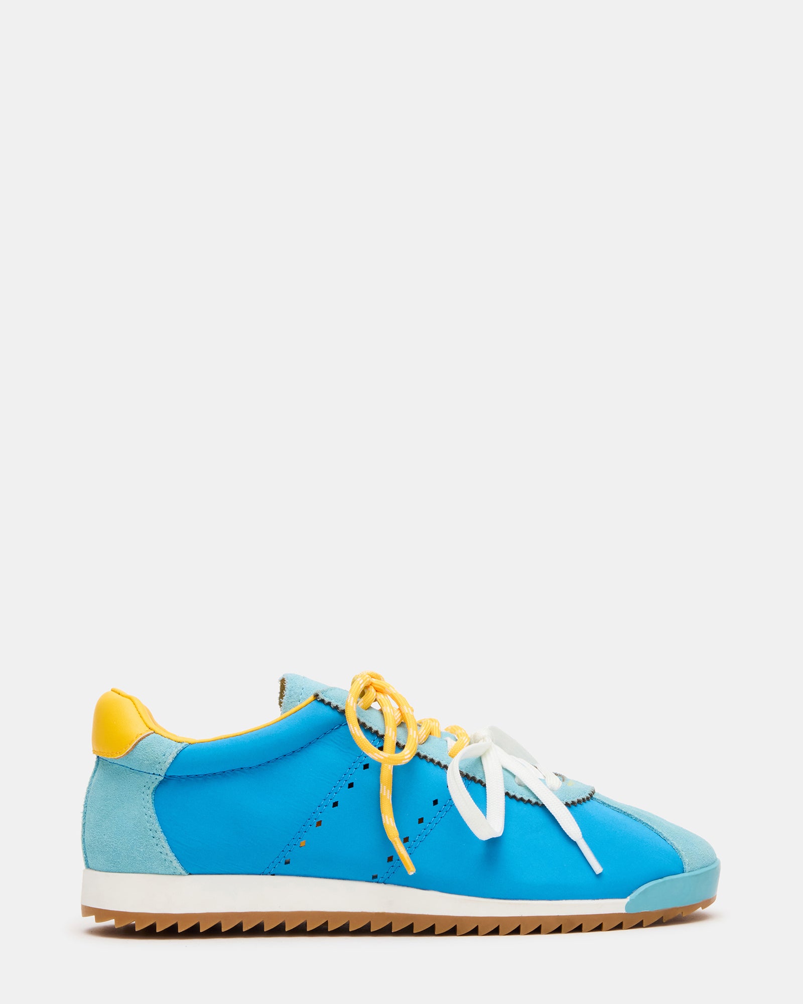 Side view of white sneakers with blue/yellow accents, styled with jeans
