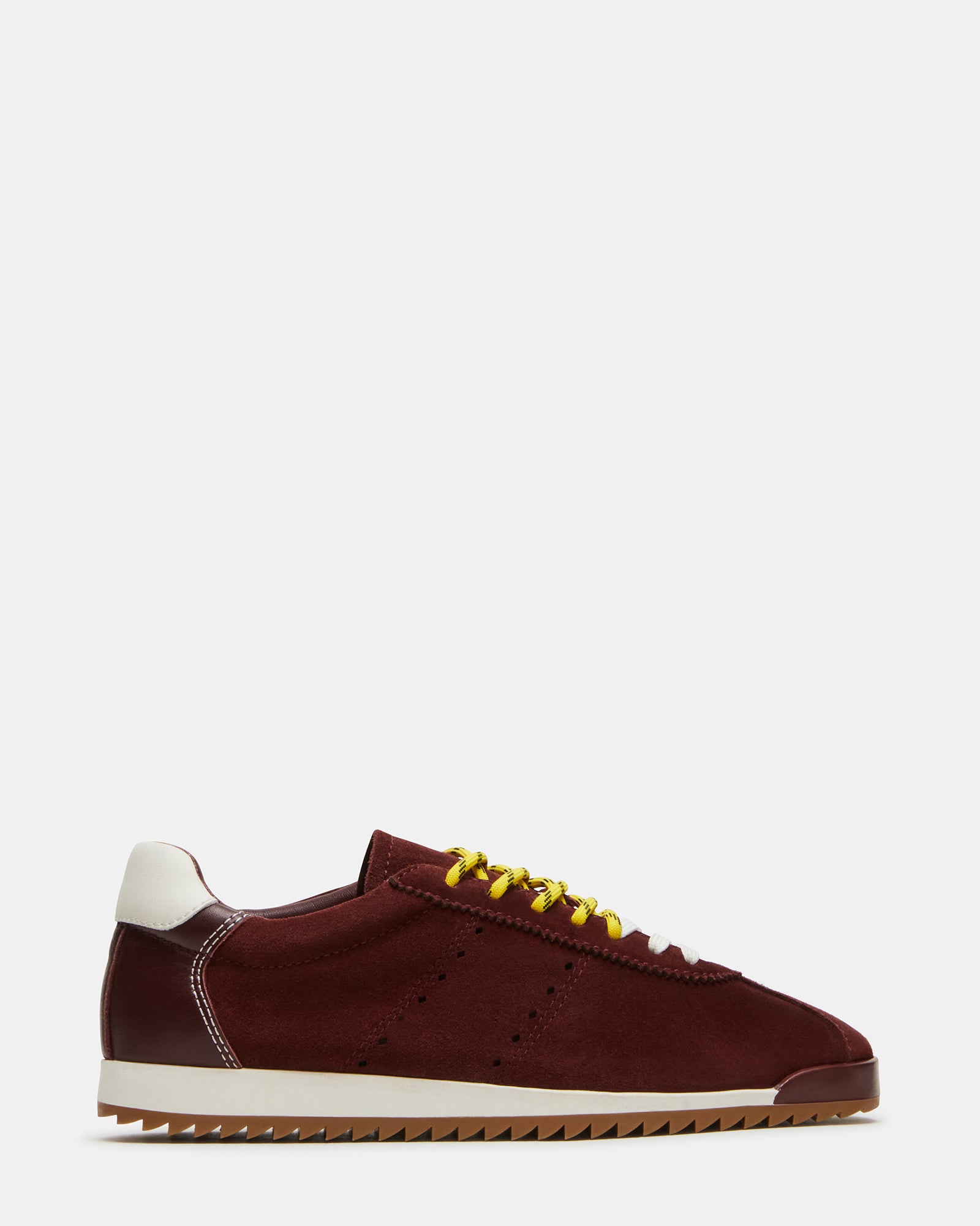 Side profile of athletic sneakers shoes on city pavement