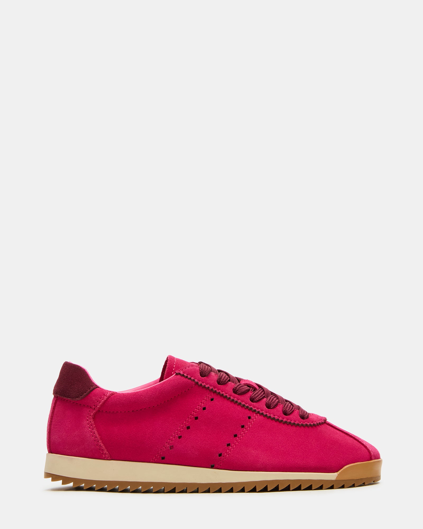 Side view of hot pink women's lace-up sneakers on a sidewalk.