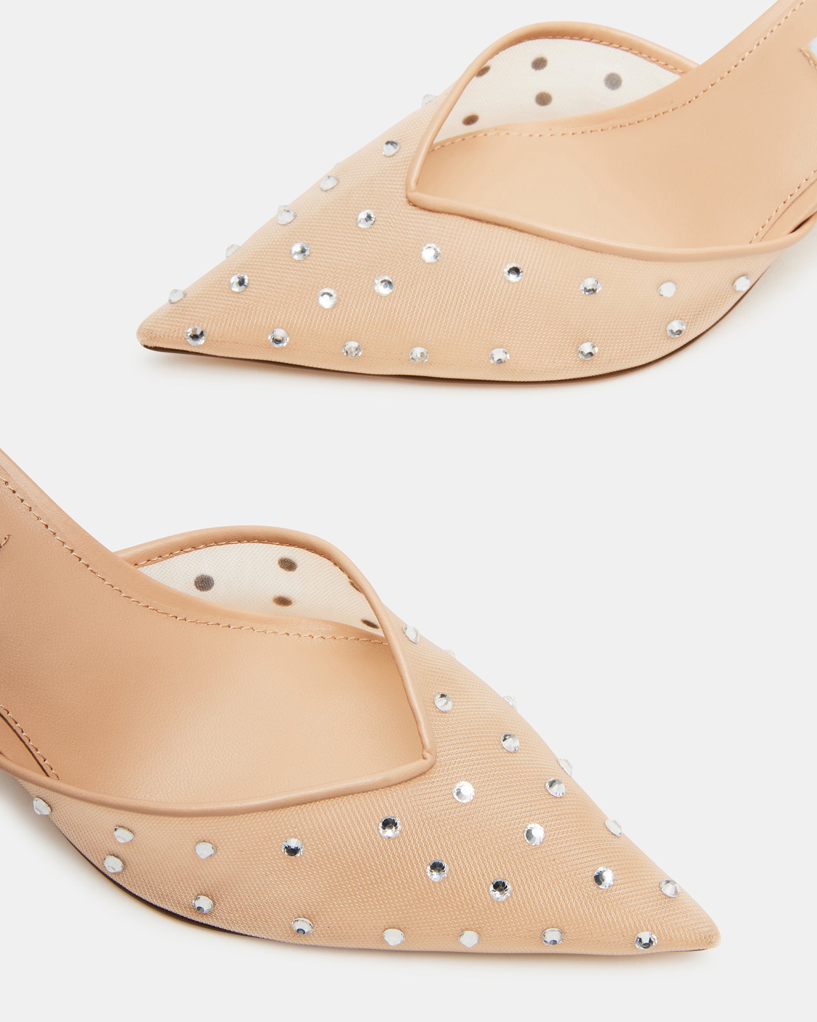 Overhead shot of nude kitten heels styled beside accessories for date night outfit