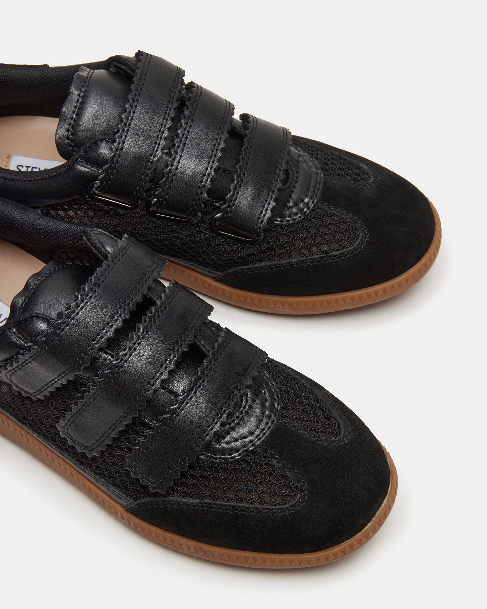 Lifestyle shot of women wearing black mesh Velcro sneakers during outdoor activities.