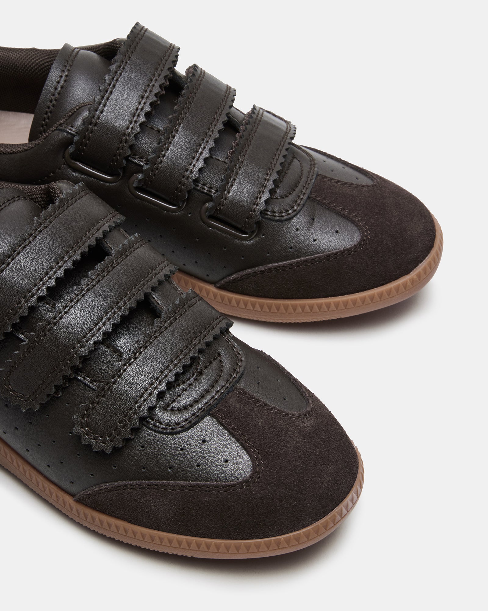 Close-up of brown suede sneakers showing Velcro strap detail