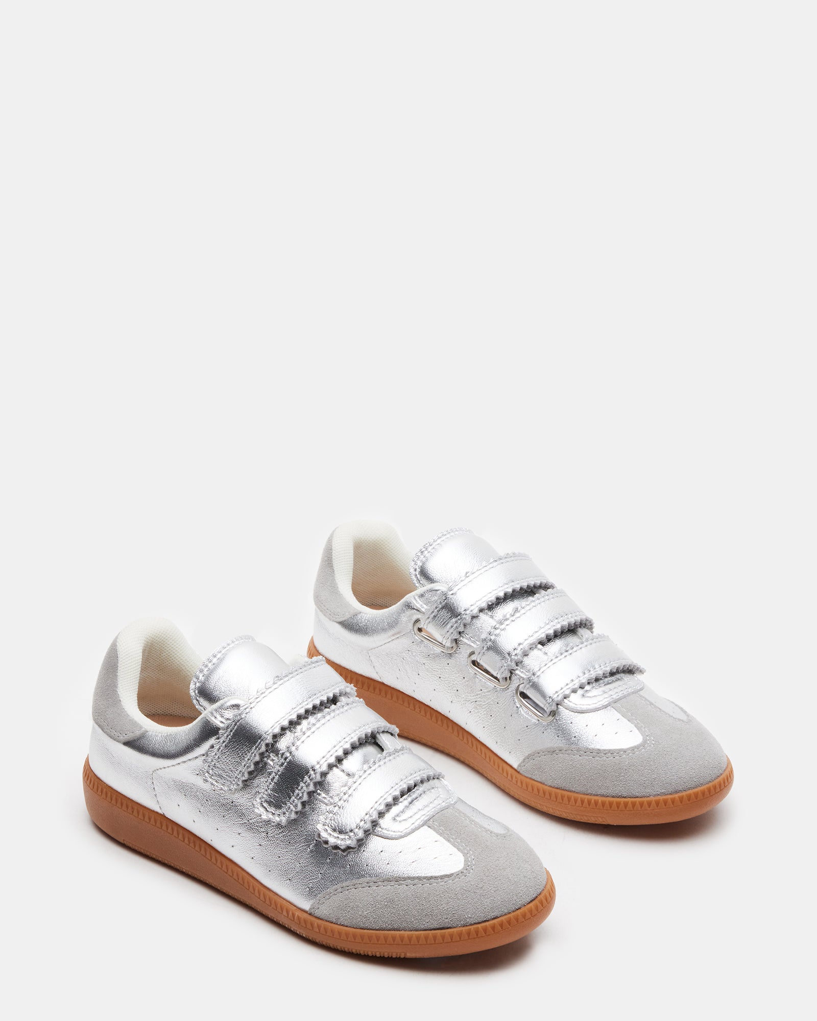 Lifestyle shot of man wearing mens white leather sneakers while walking through city park