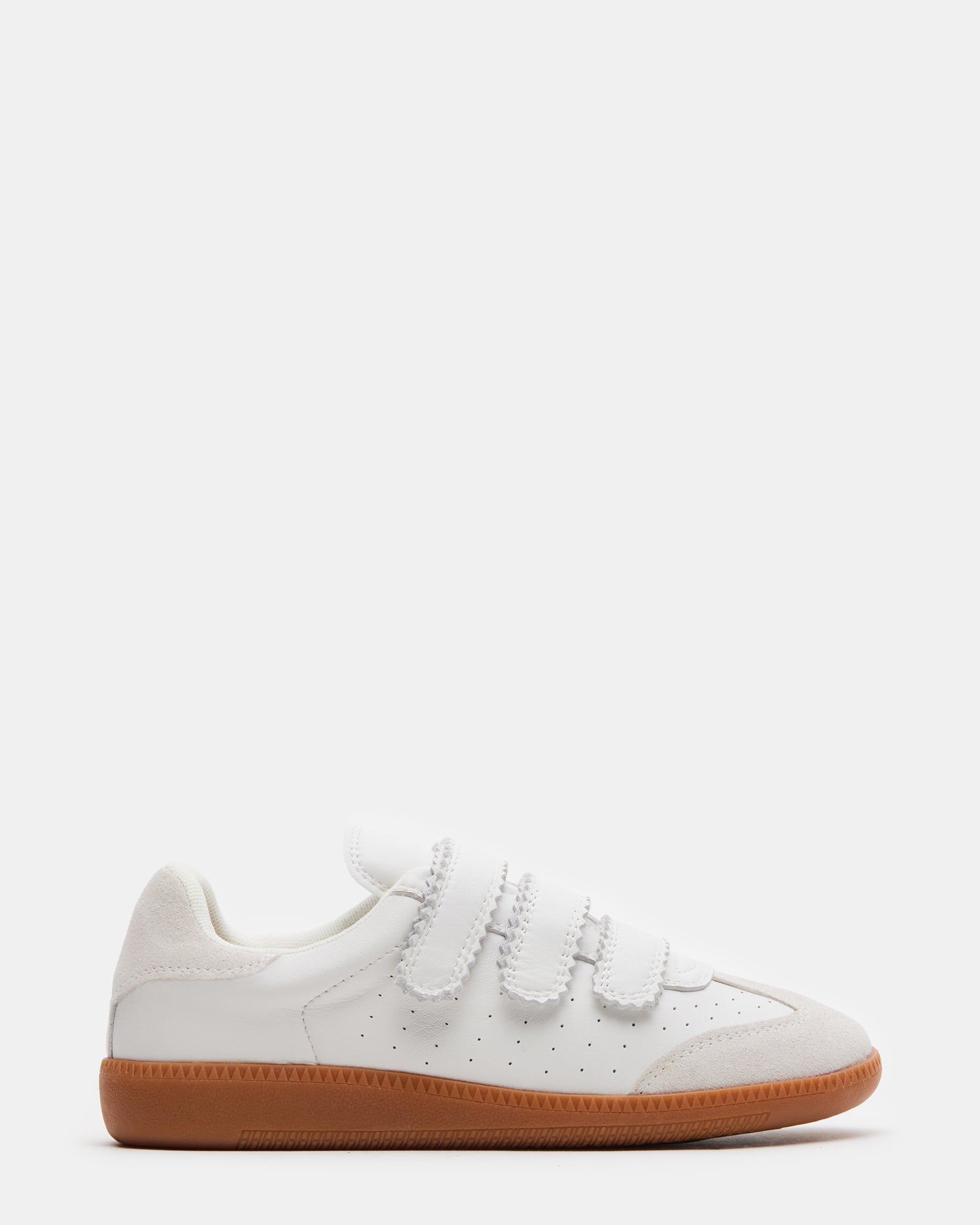 A pair of Momentum White Velcro sneakers on a wooden floor, highlighting their sleek design.