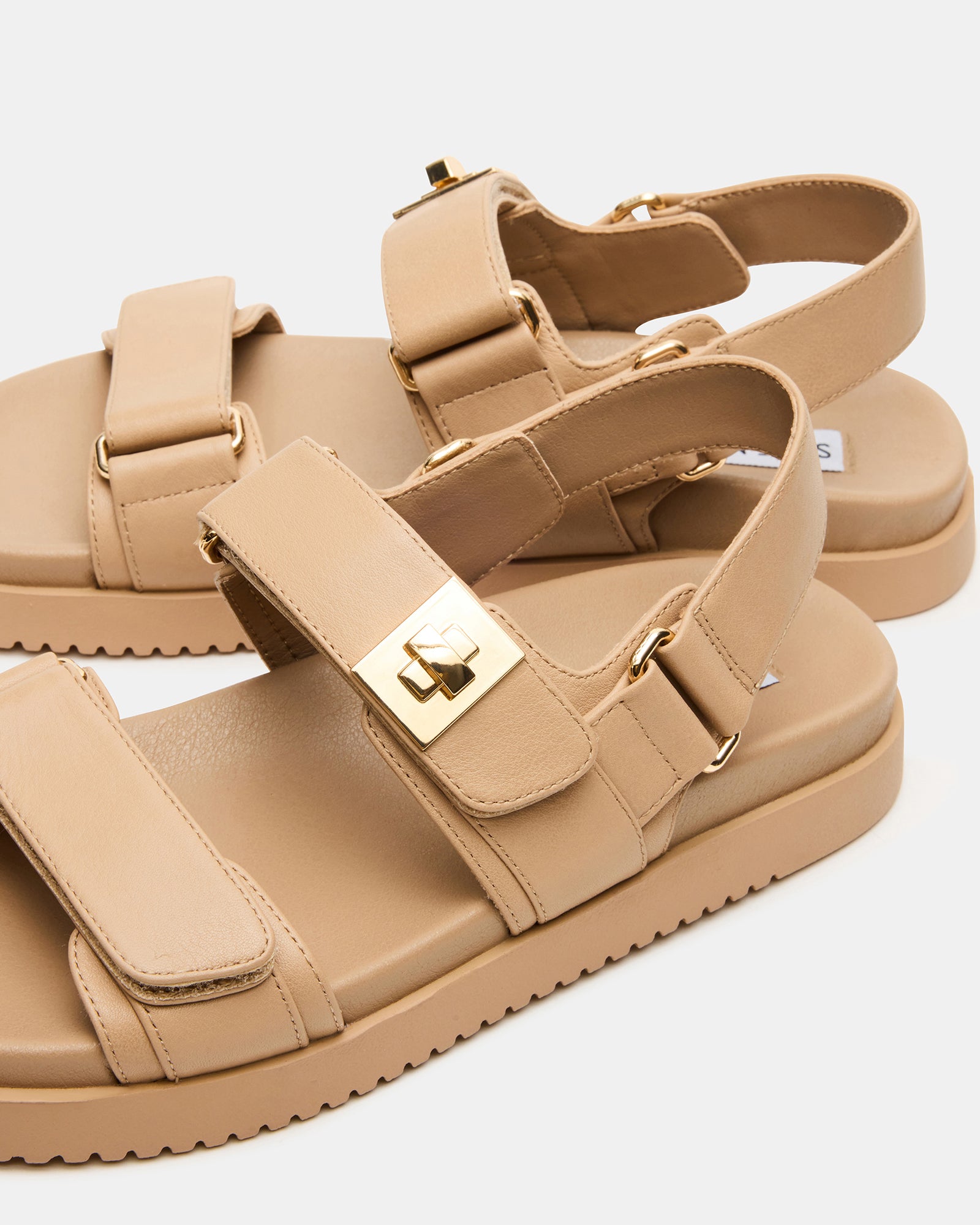 MONA beige leather sandals on a wooden deck, showcasing the flatform sole and adjustable straps.