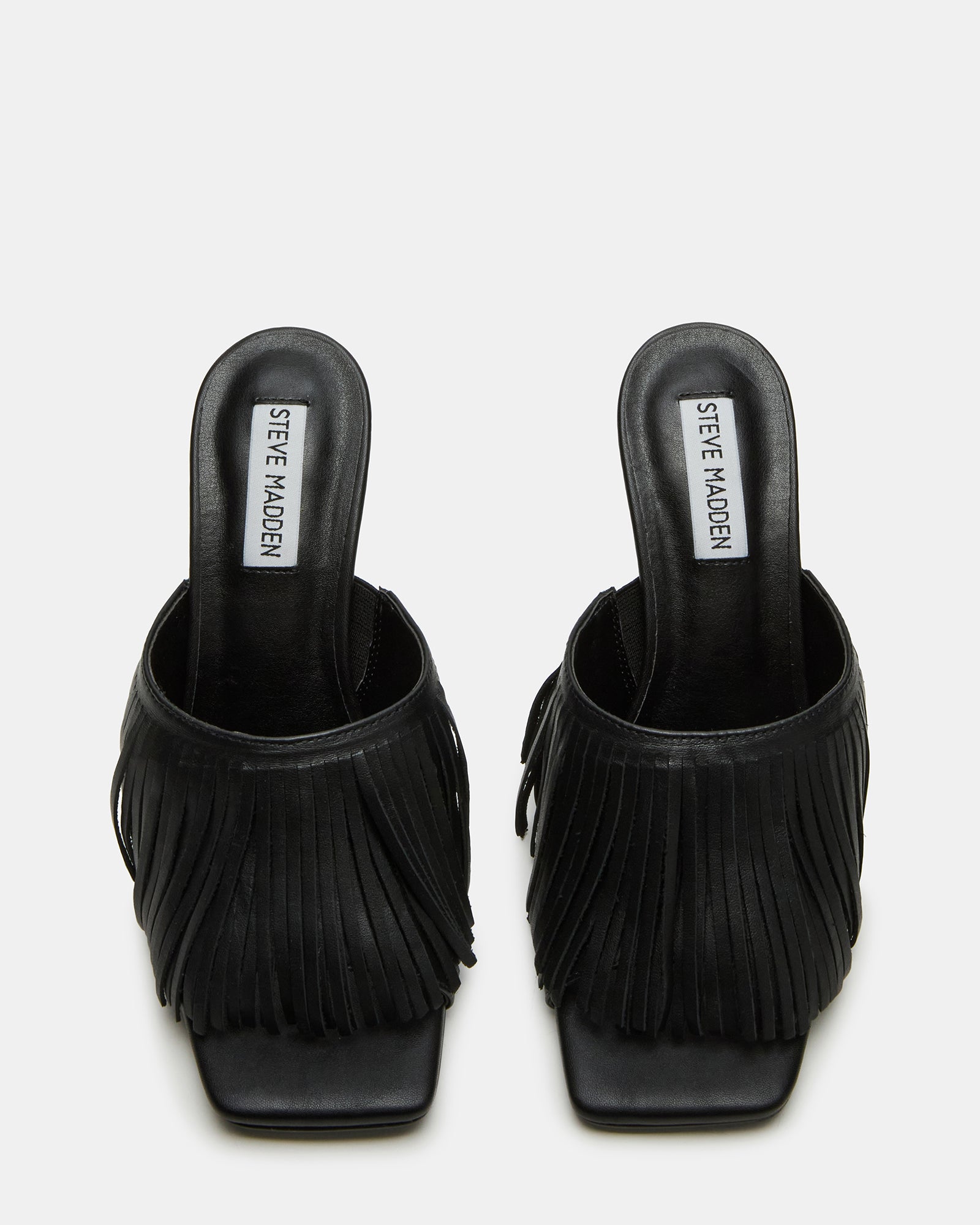 Side view of black strappy heels showcasing the fringe detail and square toe.