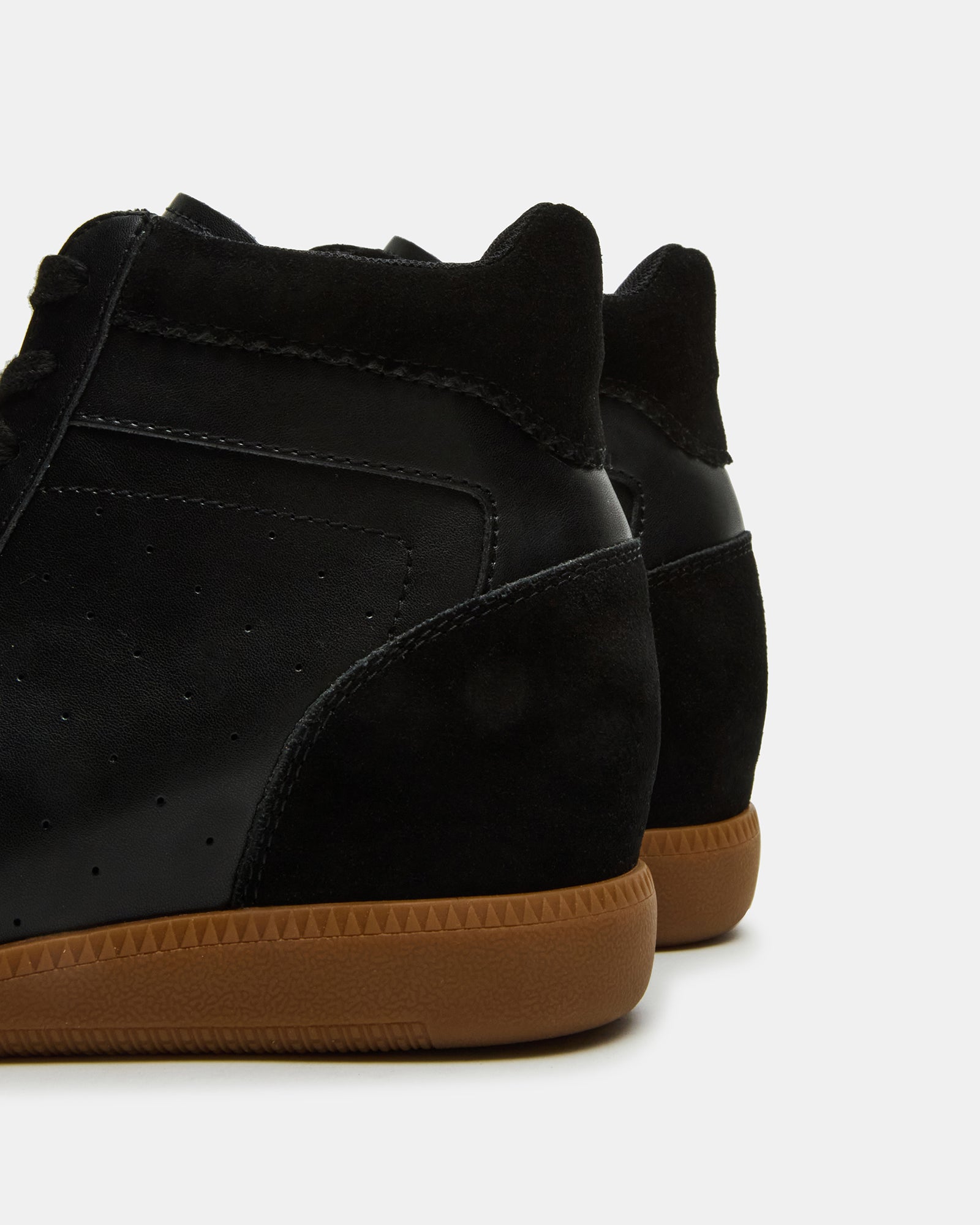 Close-up of the lace-up closure on black high-top sneakers