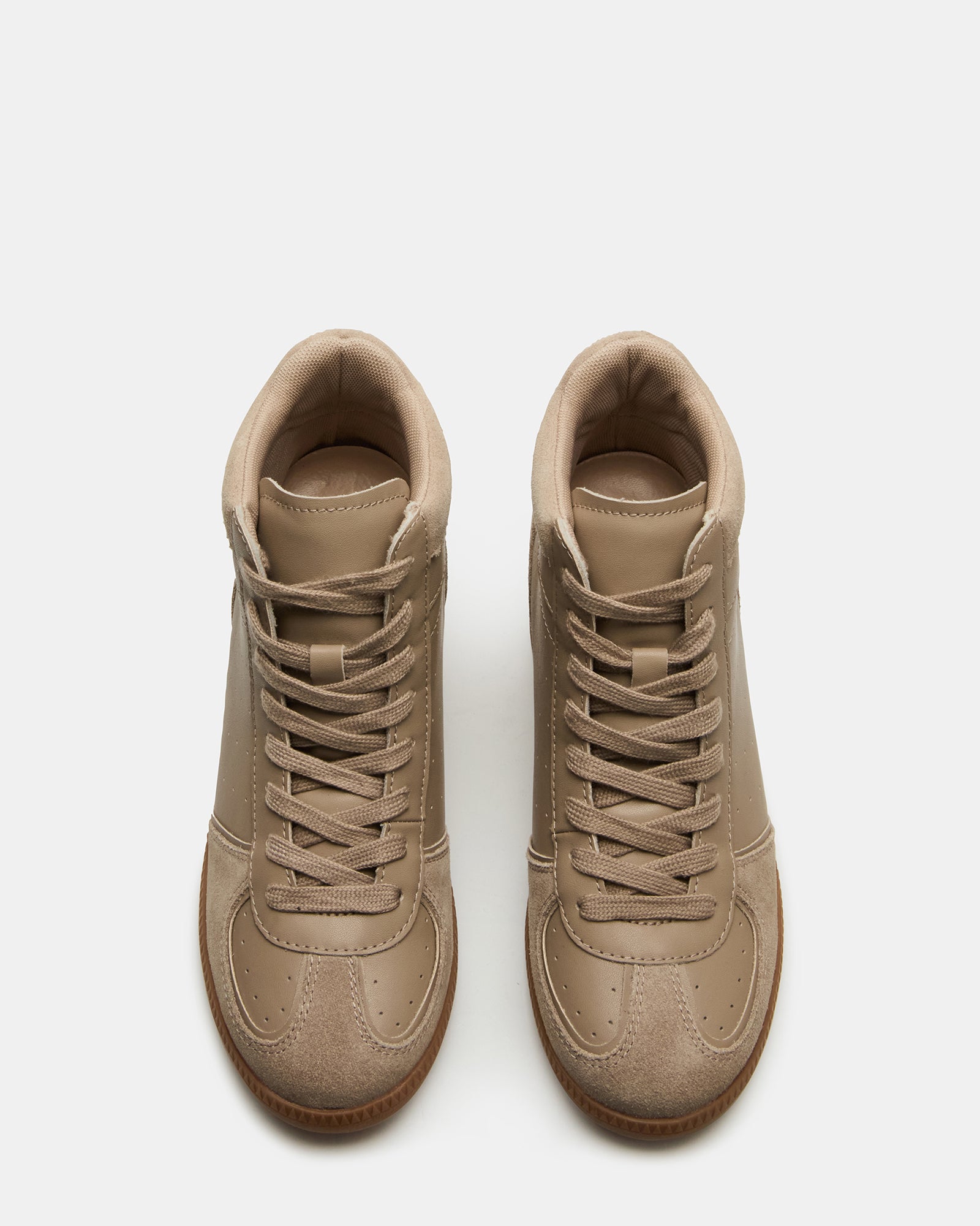 Side angle of taupe lace-up high-top sneakers with hidden wedge on city pavement