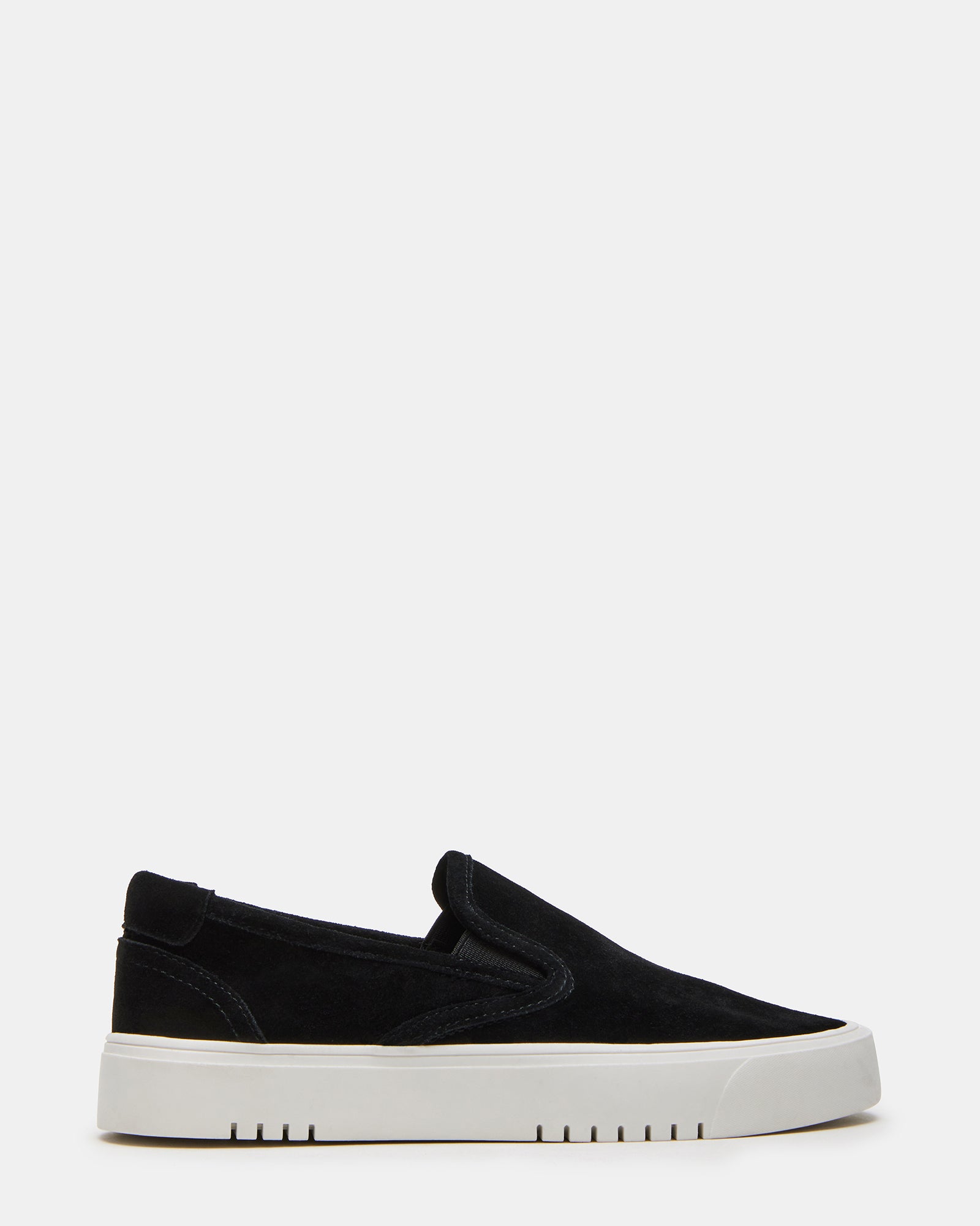 Side profile of black suede low top sneakers with rounded toe on wooden floor