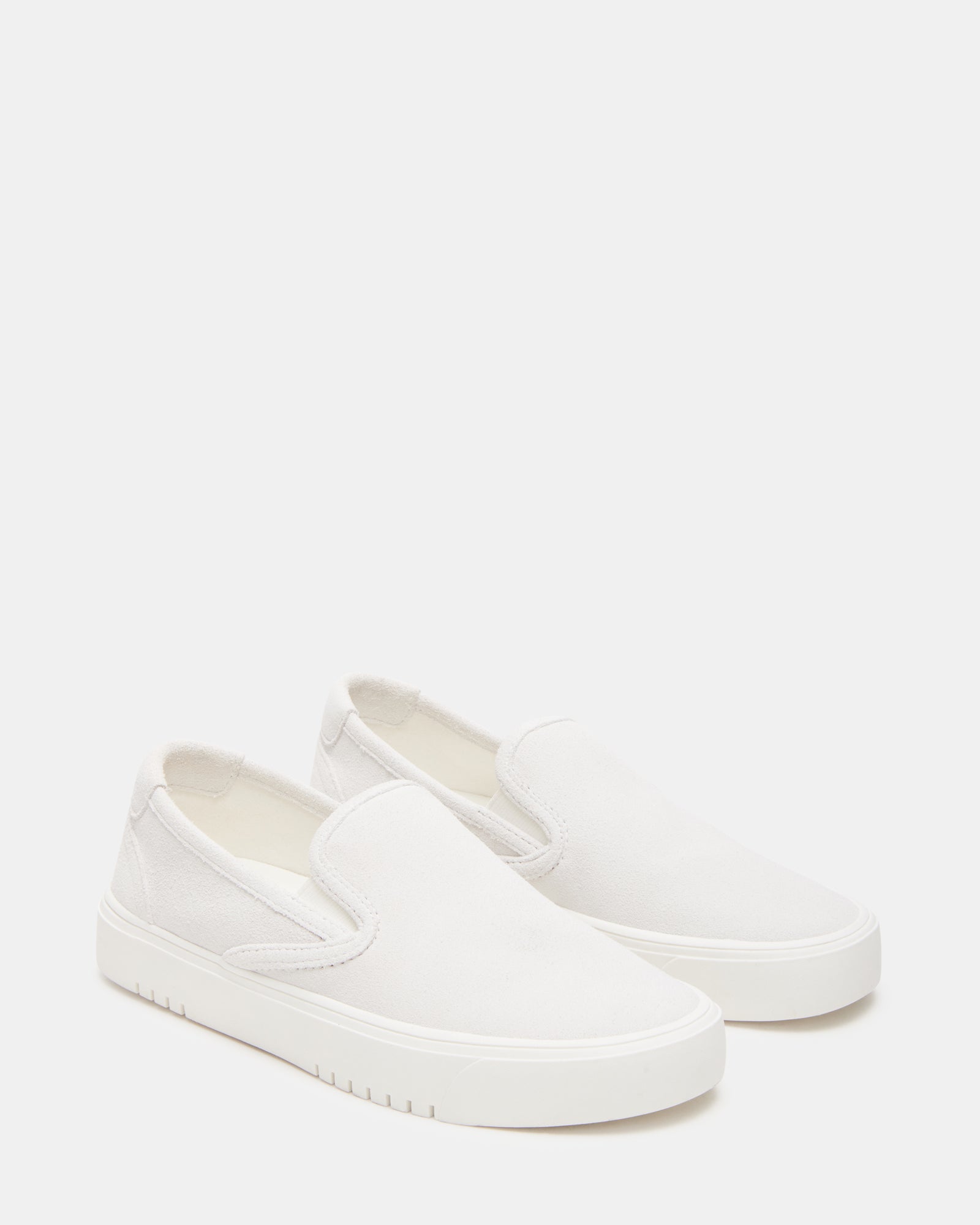 Close-up of rounded toe and heel design on white suede shoes