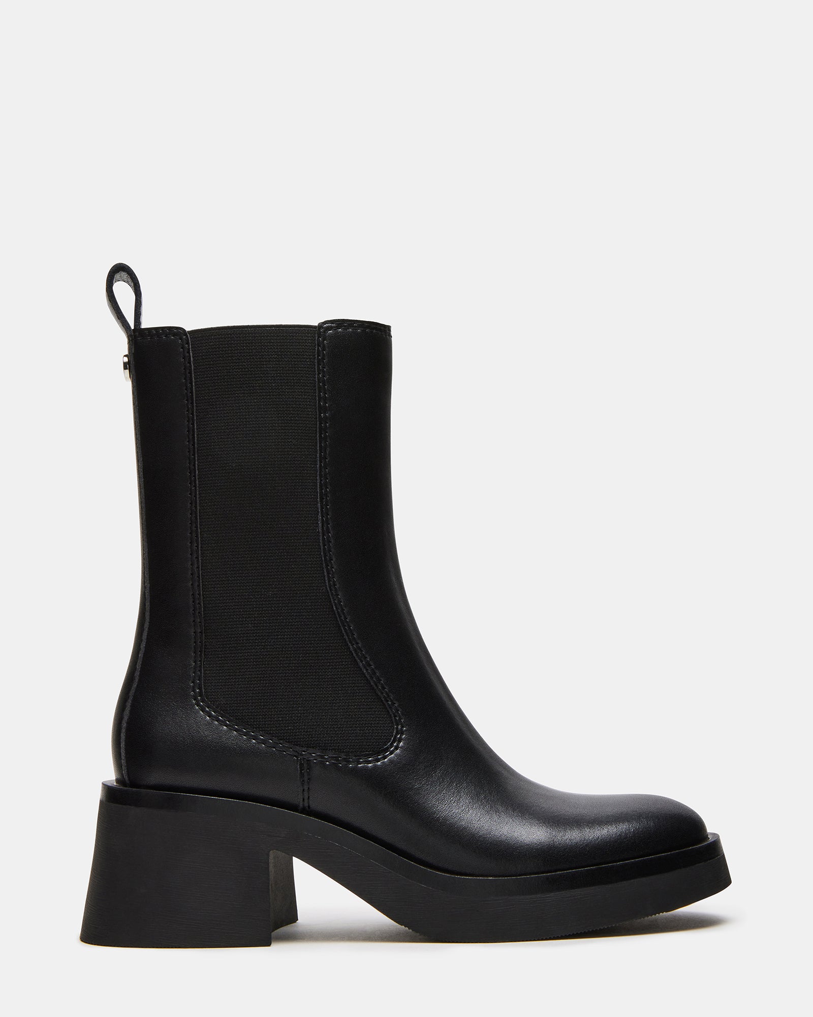 Side profile of black chelsea boots with rounded toe on hardwood floor