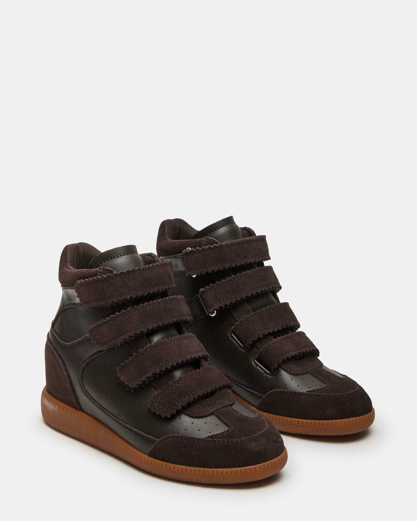 Side view of high-top sneakers with hidden wedge on a city street