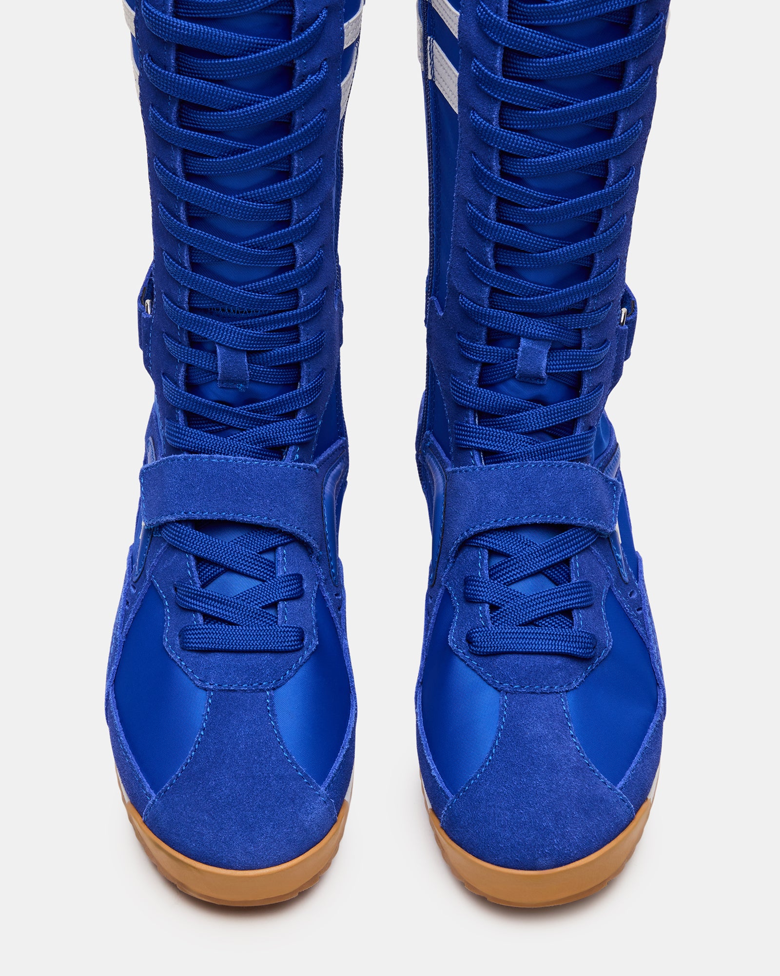 Side view of MYRCELLA Blue Multi high-top sneakers on a woman’s feet, showcasing the stylish design