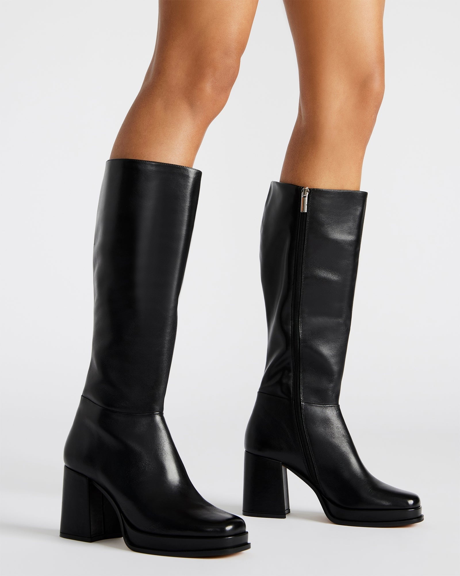 Side view of black leather boots showcasing shaft height and sturdy heel