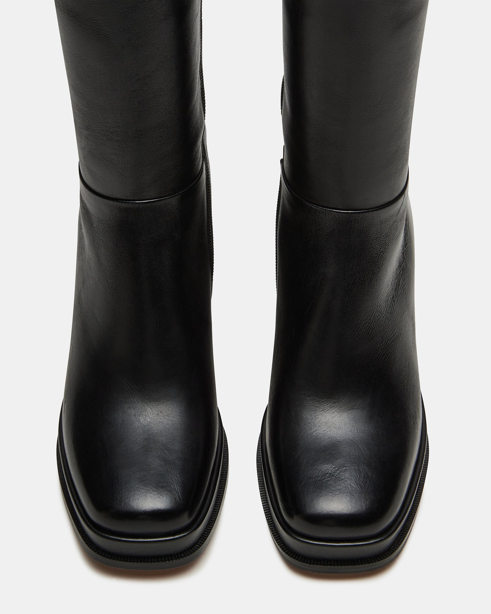 Side view of black leather boots showcasing shaft height and sturdy heel