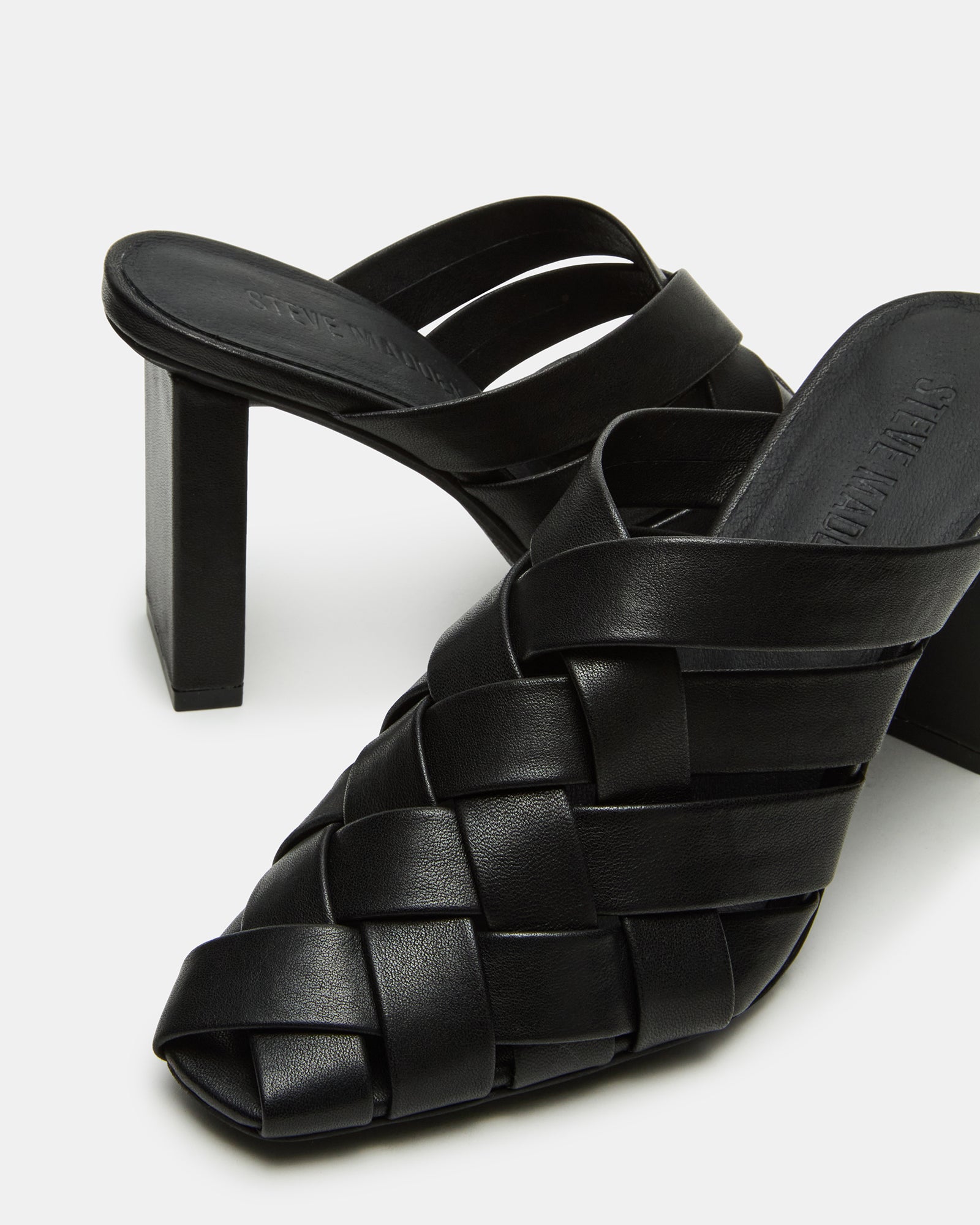 Close-up of white mule high heels variant showing woven detail and heel height