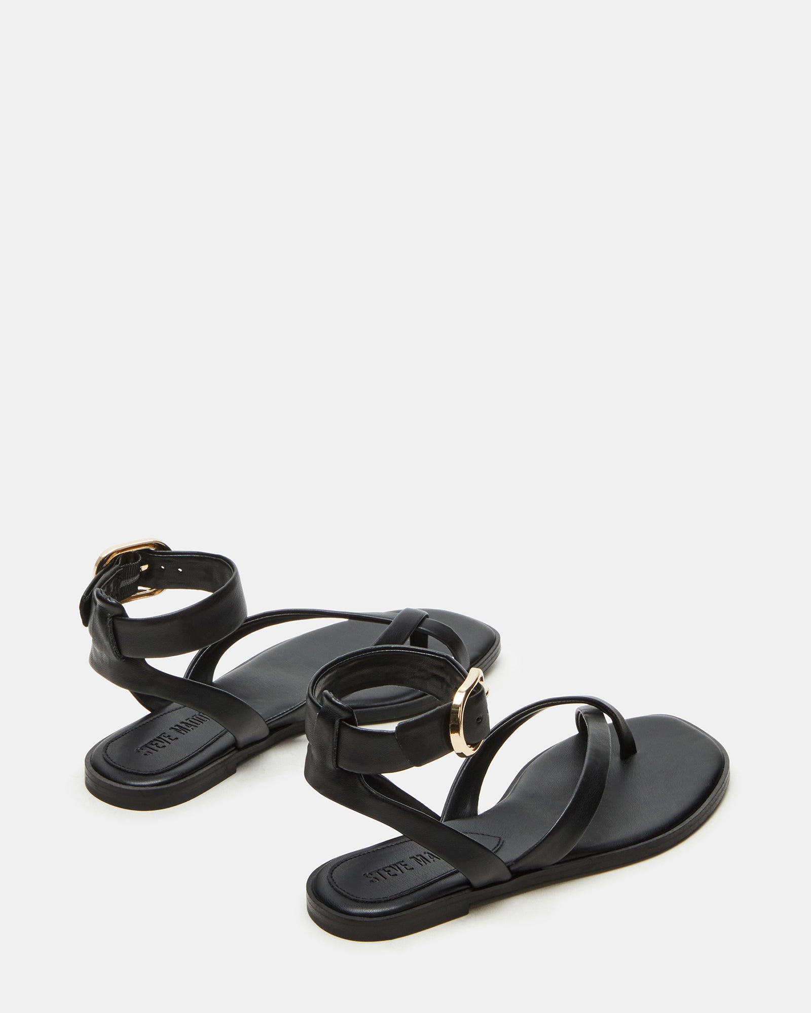 Model wearing black vegan leather flat sandals with ankle strap and casual outfit