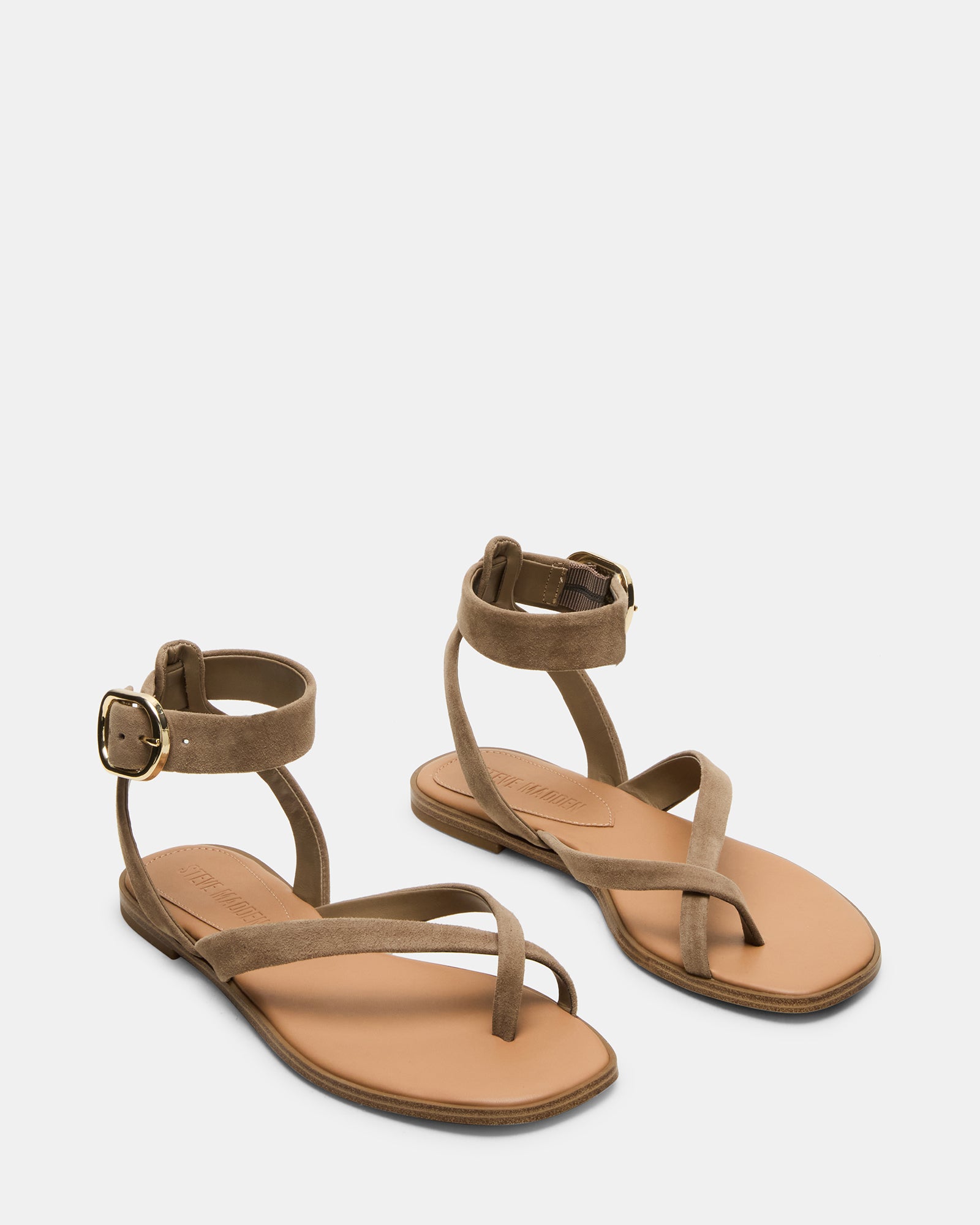 Side profile showing white flat sandals with low heel and flexible sole