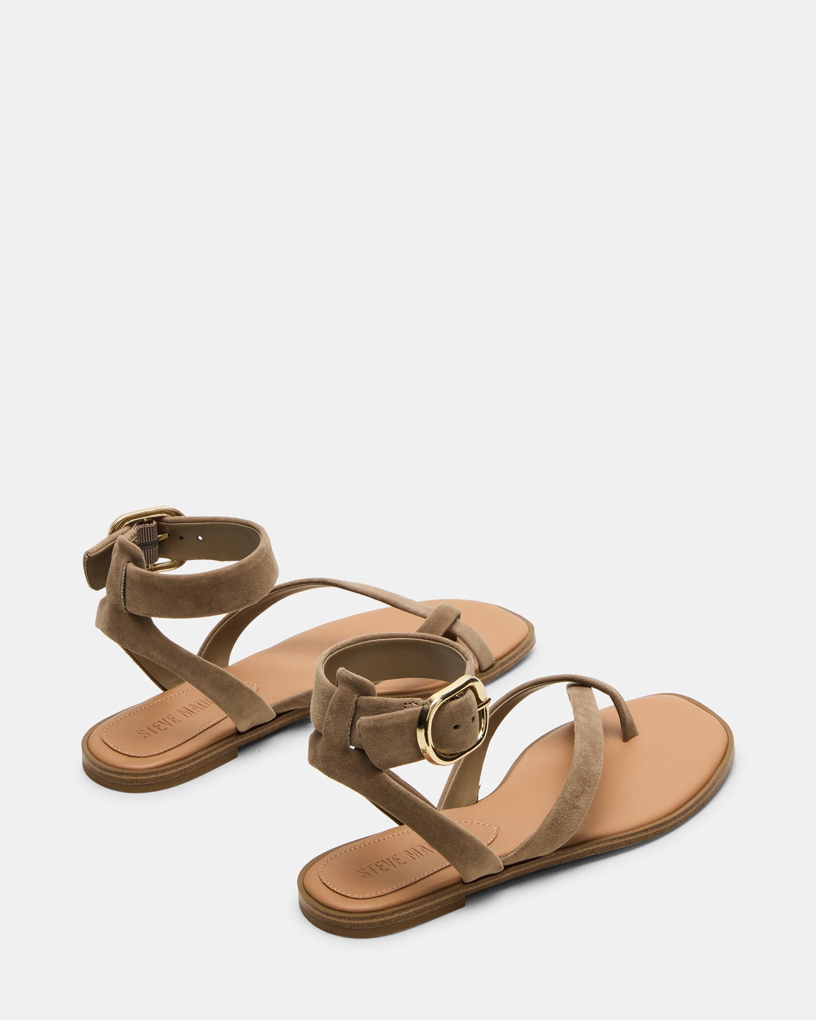 Side profile showing white flat sandals with low heel and flexible sole