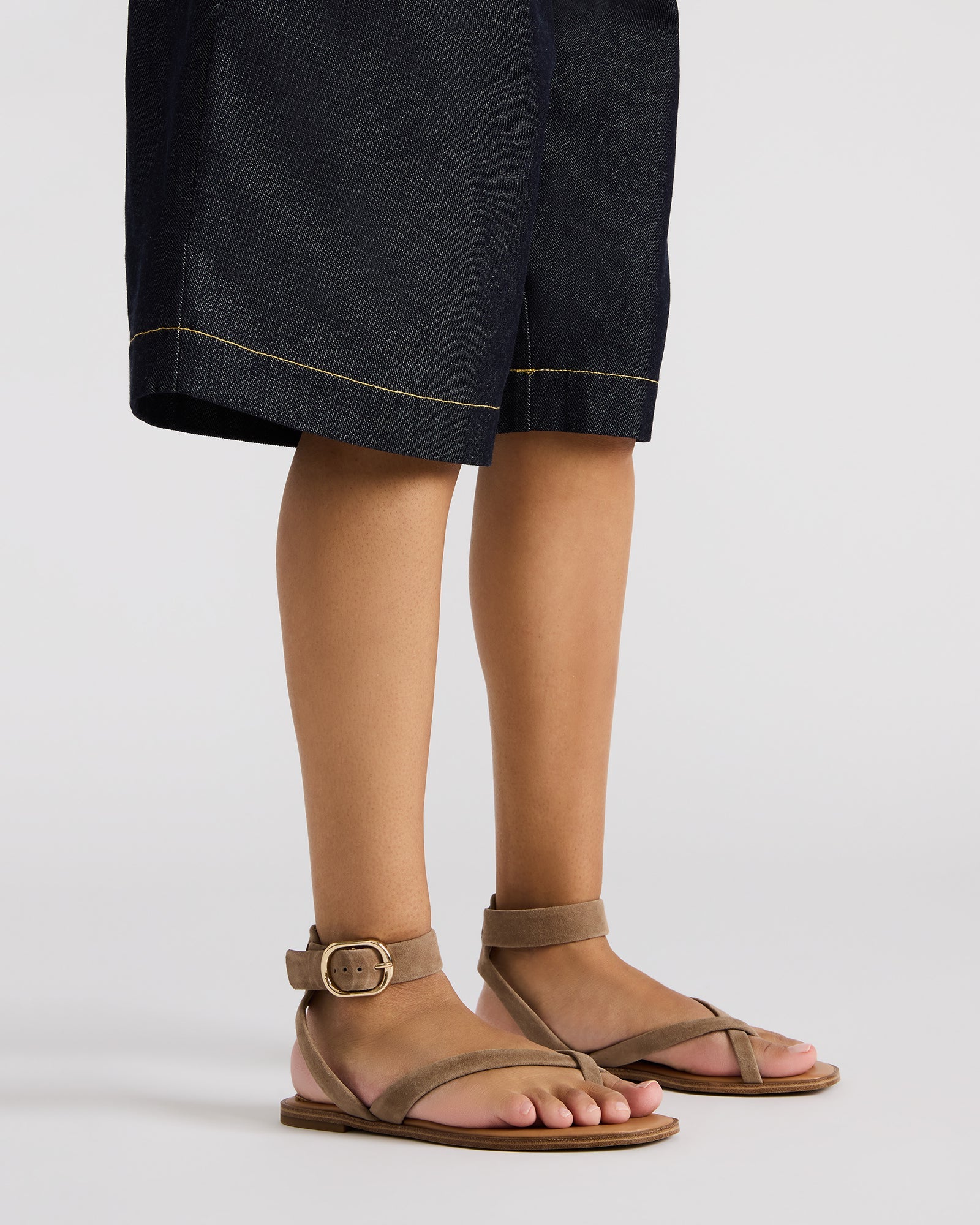 Close-up of black flat sandals ankle strap detail and suede texture for comfort