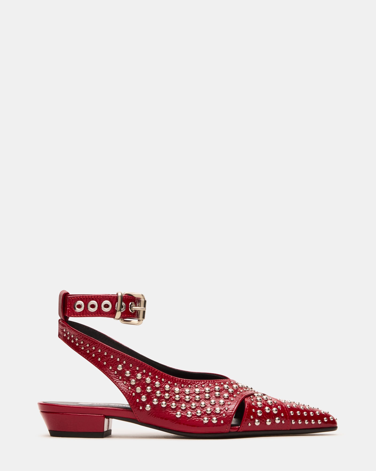 Close-up of red leather pointed toe slingback flats with stud embellishments on a wooden surface
