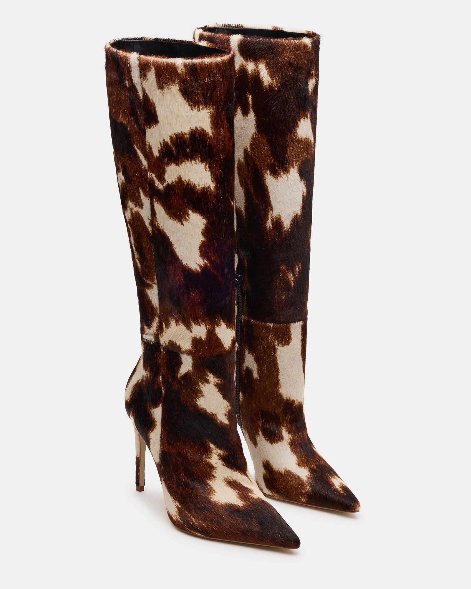 Close-up of pointed toe and stiletto heel on cow print boots