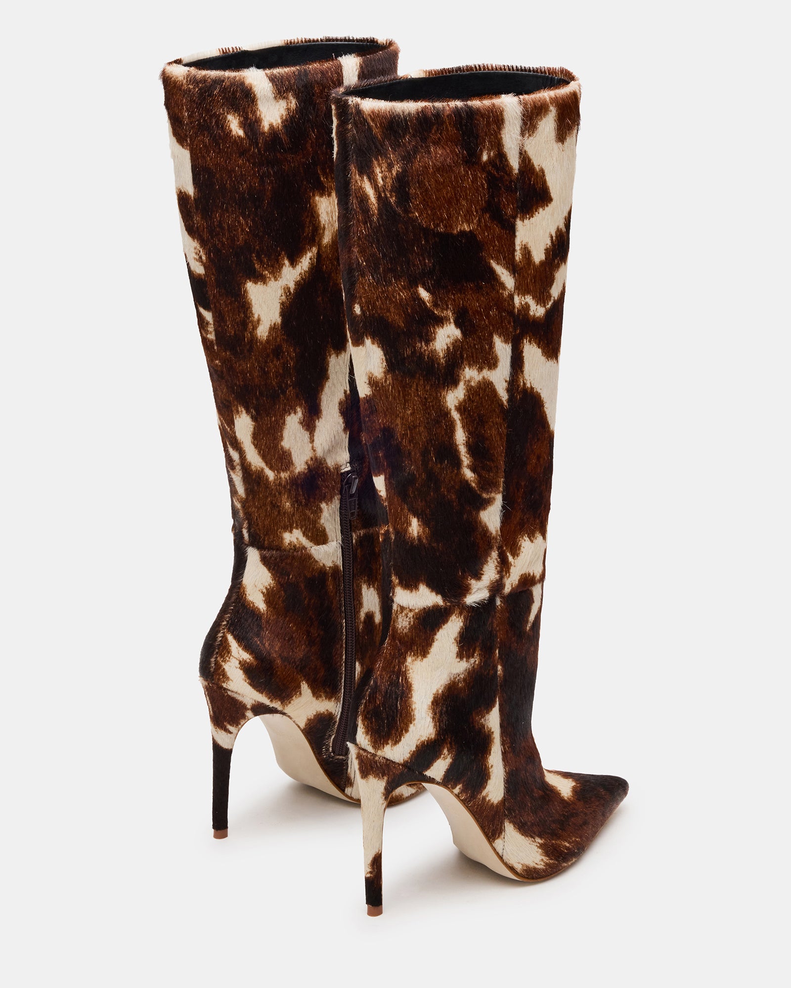 Close-up of pointed toe and stiletto heel on cow print boots