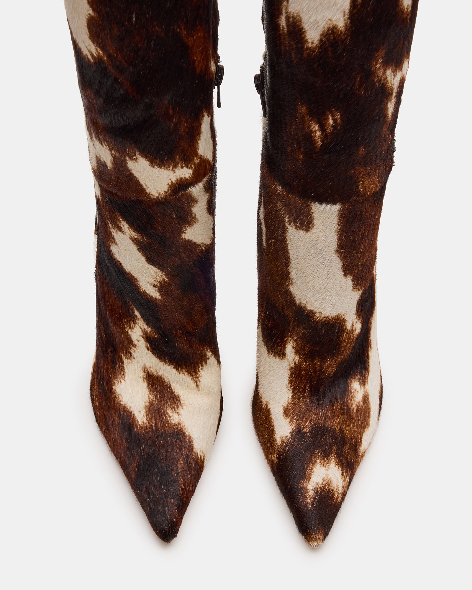 Side view of cow print western stiletto boots with jeans