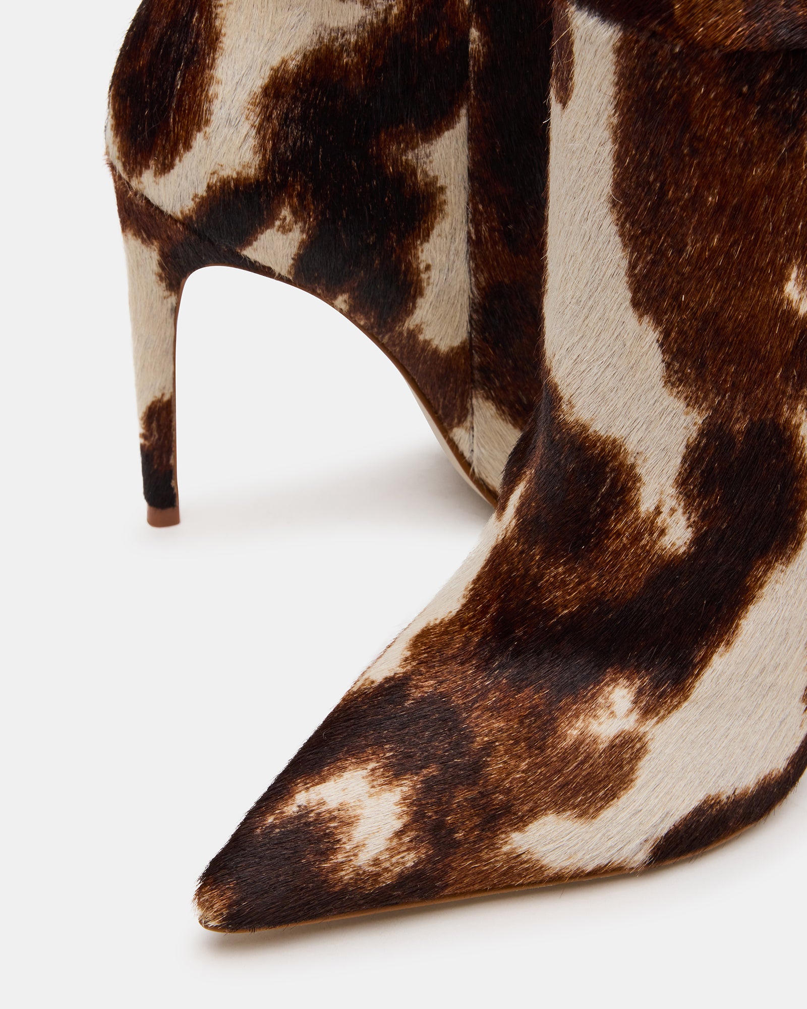 Full view of cow print cowboy boots worn at a casual gathering