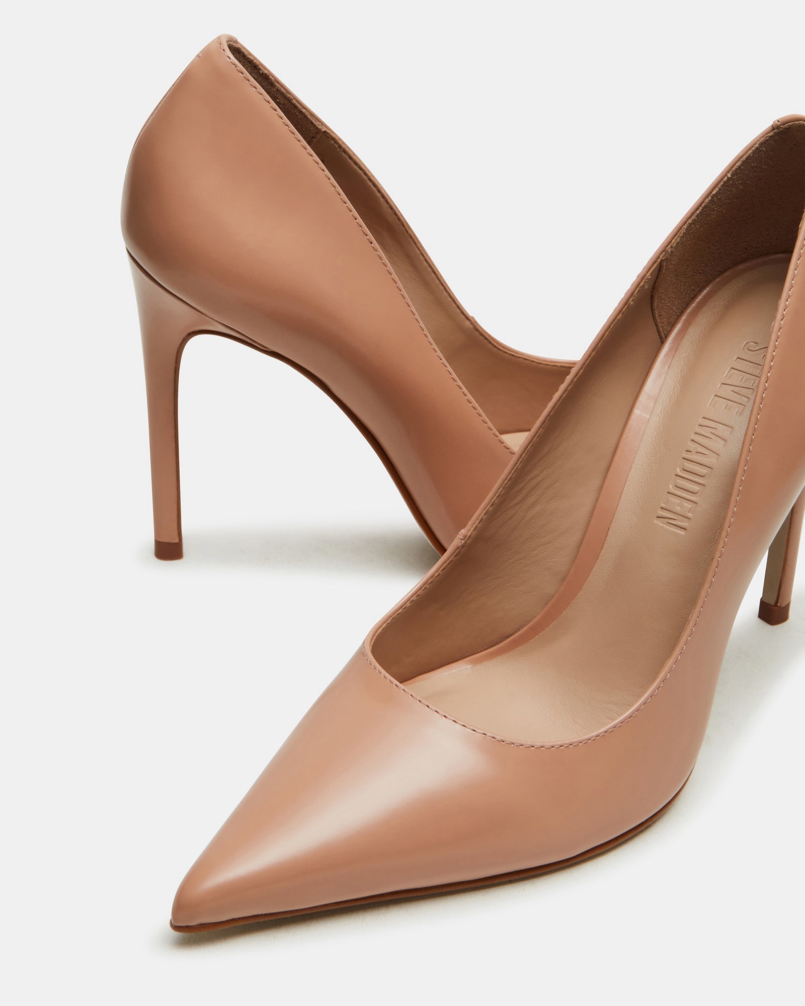 Side profile of black stiletto heels on white background showing heel height and material finish