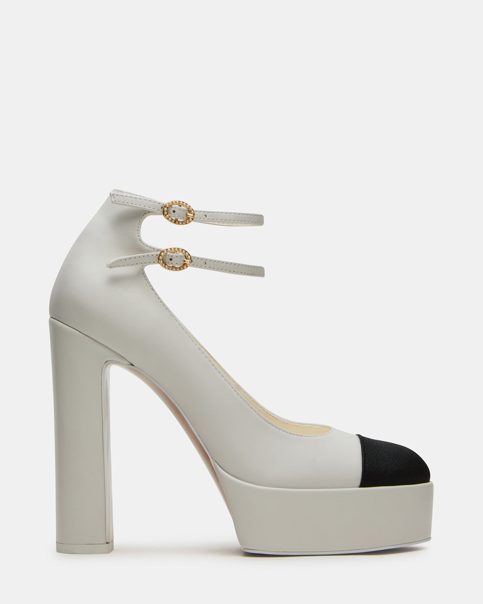 Close-up of white leather heels showing toe cap detail and textured upper
