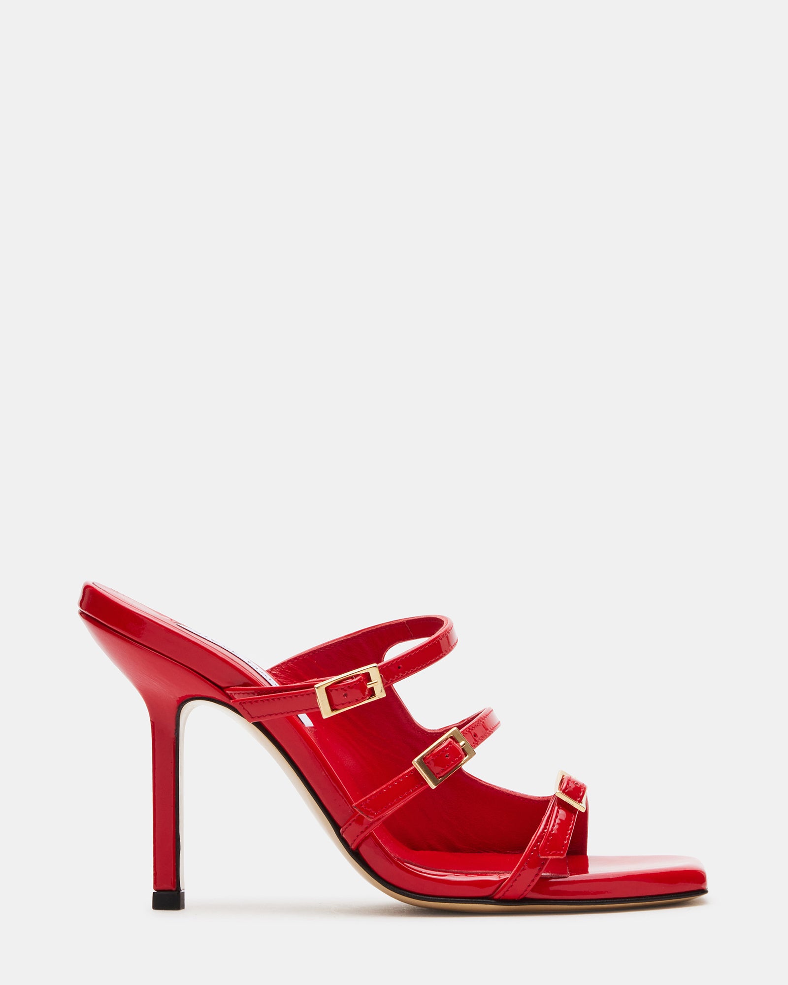 Opulent red patent leather high heels – side view on marble floor