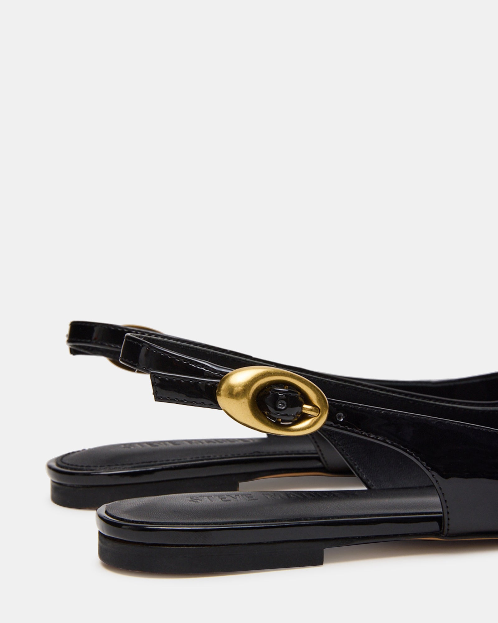 Side view of black patent slingback flats, ideal for office wear.