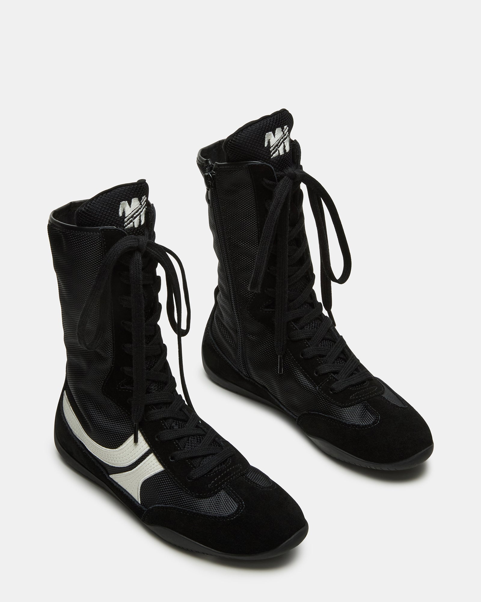 Side profile of lace-up sneakers showing the layered suede and textile upper
