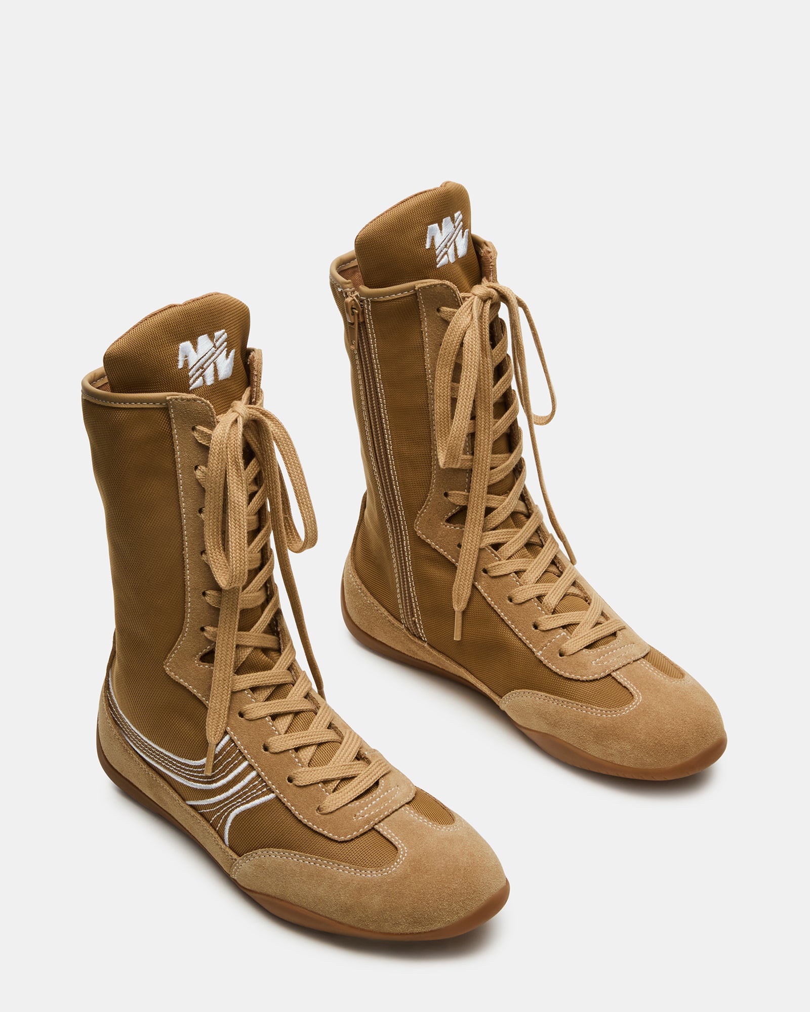 Close-up of lace-up closure and suede detailing on white sneakers