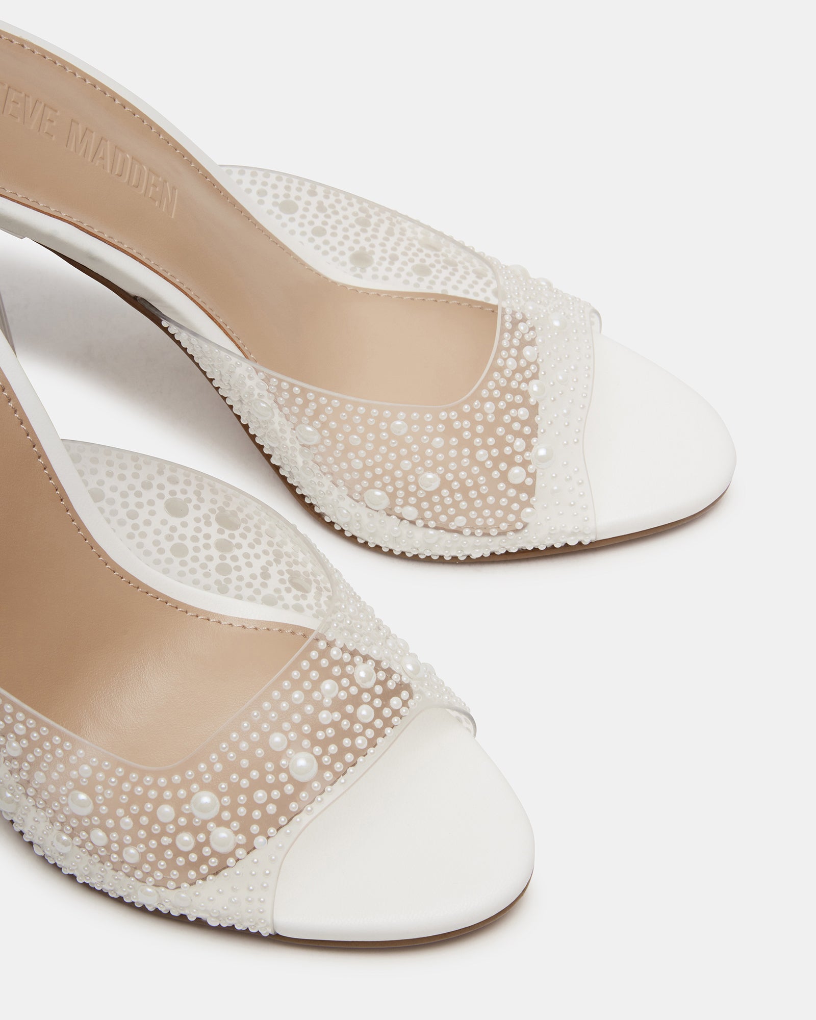 Close-up of the heel and sole of Peach Pearl Clear stiletto shoes, showcasing the synthetic construction