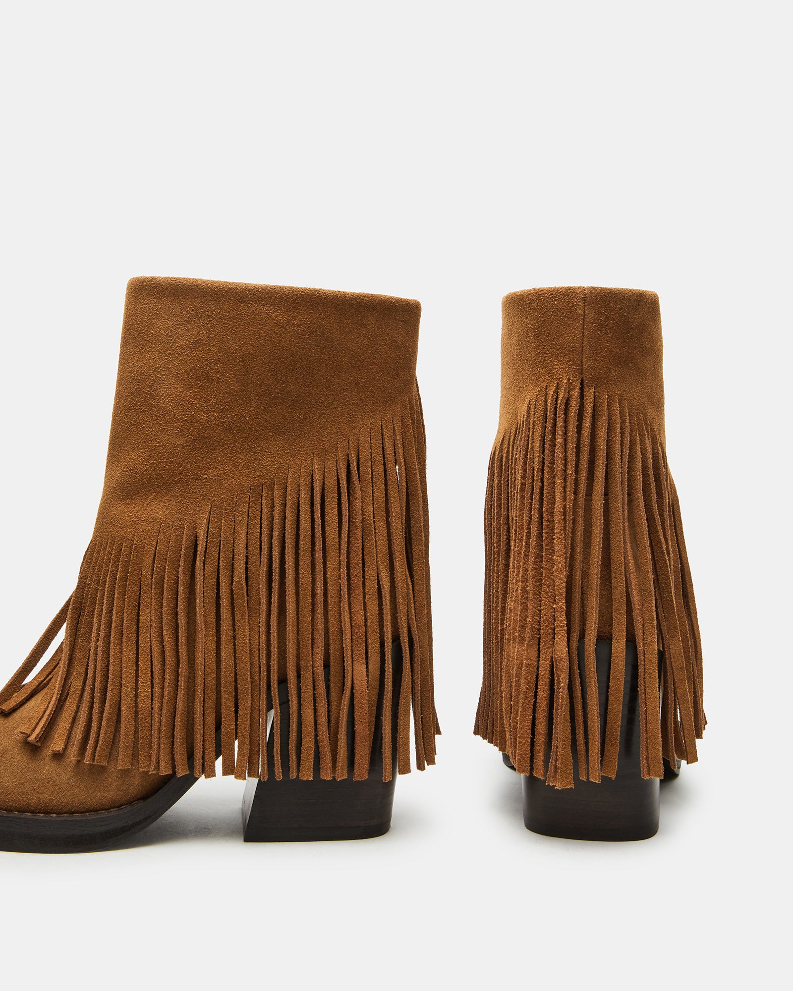 Styled black ankle boots worn with jeans in an urban street setting