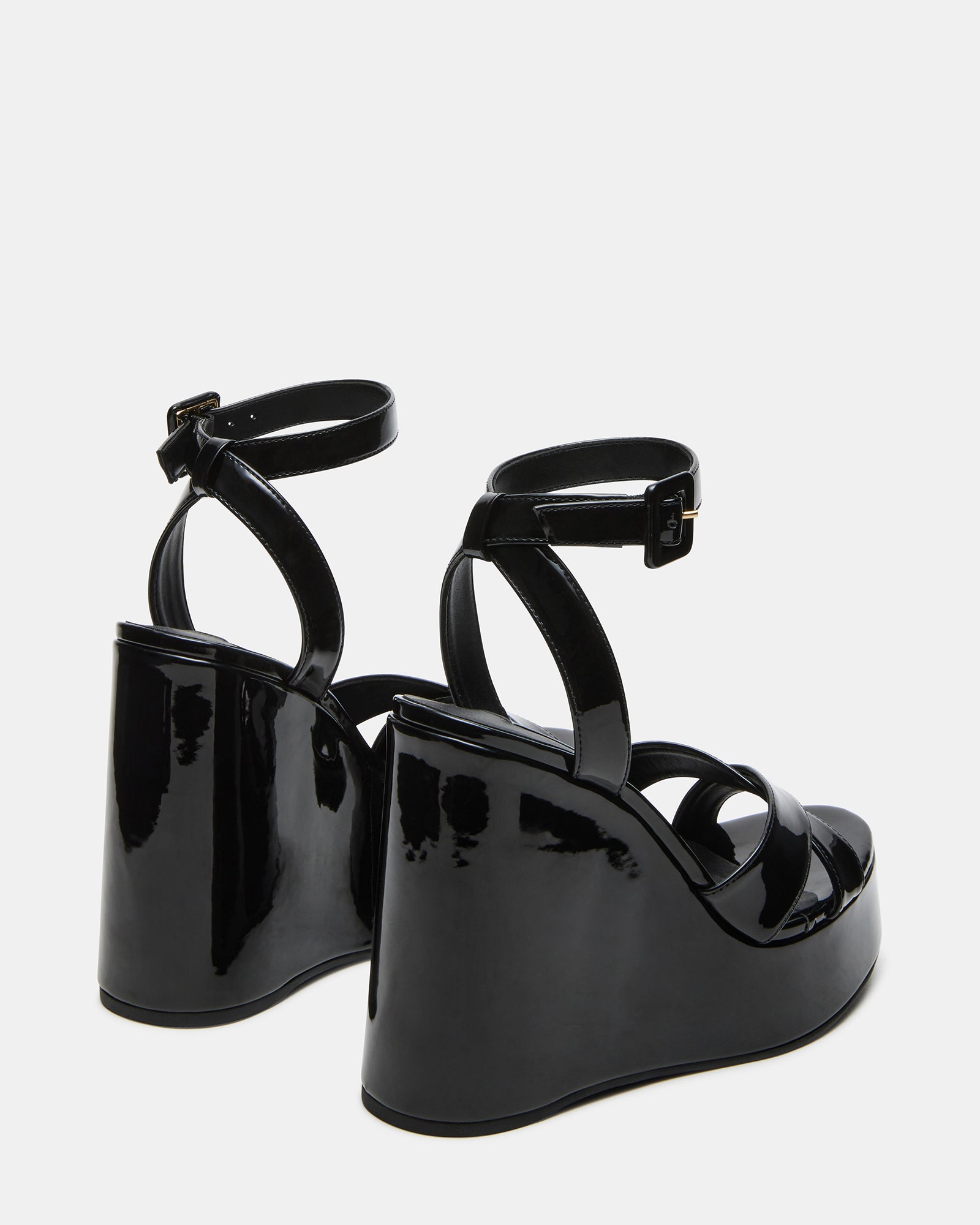 Model wearing Pinnacle black patent platform wedges for a chic look suitable for parties or casual outings