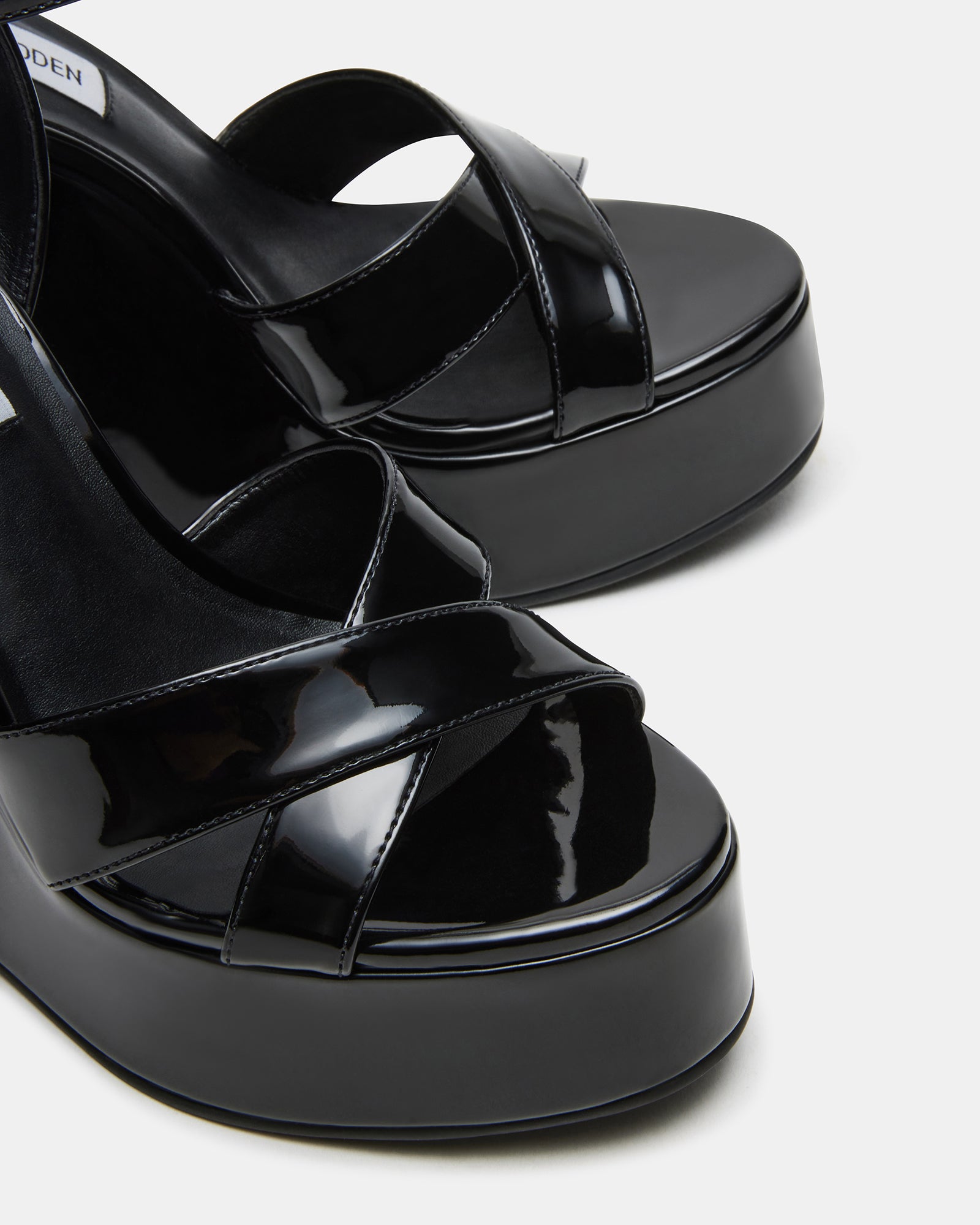 Side view of Pinnacle black patent platform wedge sandals highlighting the heel and ankle strap